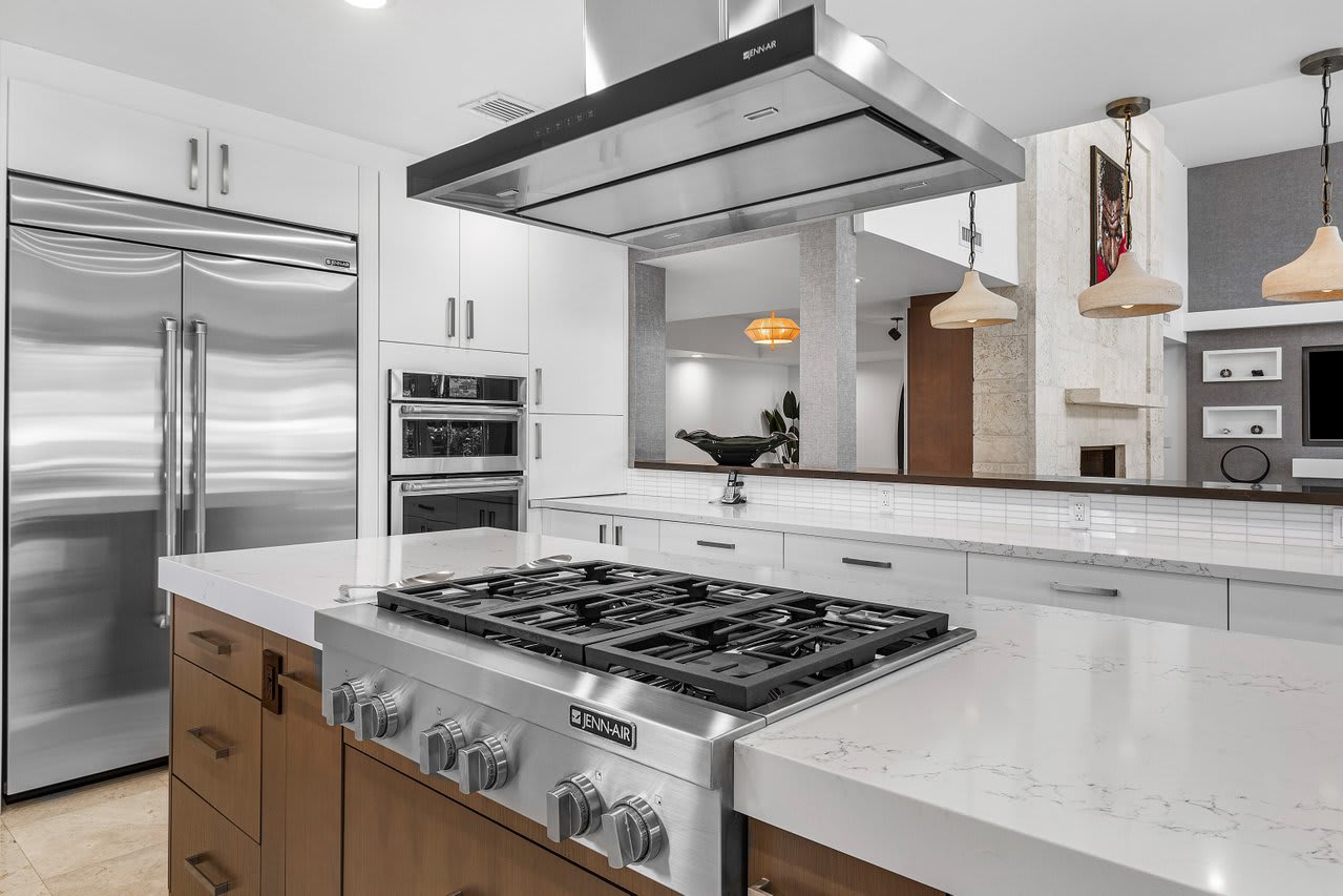 Gourmet kitchen, complete with a professional-grade gas range, stainless steel JennAir appliances, and sleek quartz countertops.