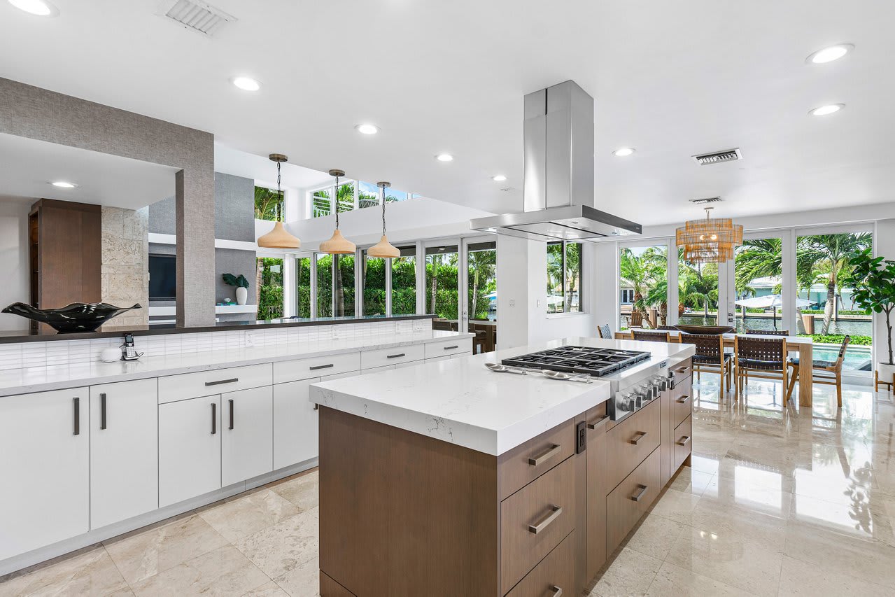 Quartz countertops, a spacious island, and elegant pendant lighting.