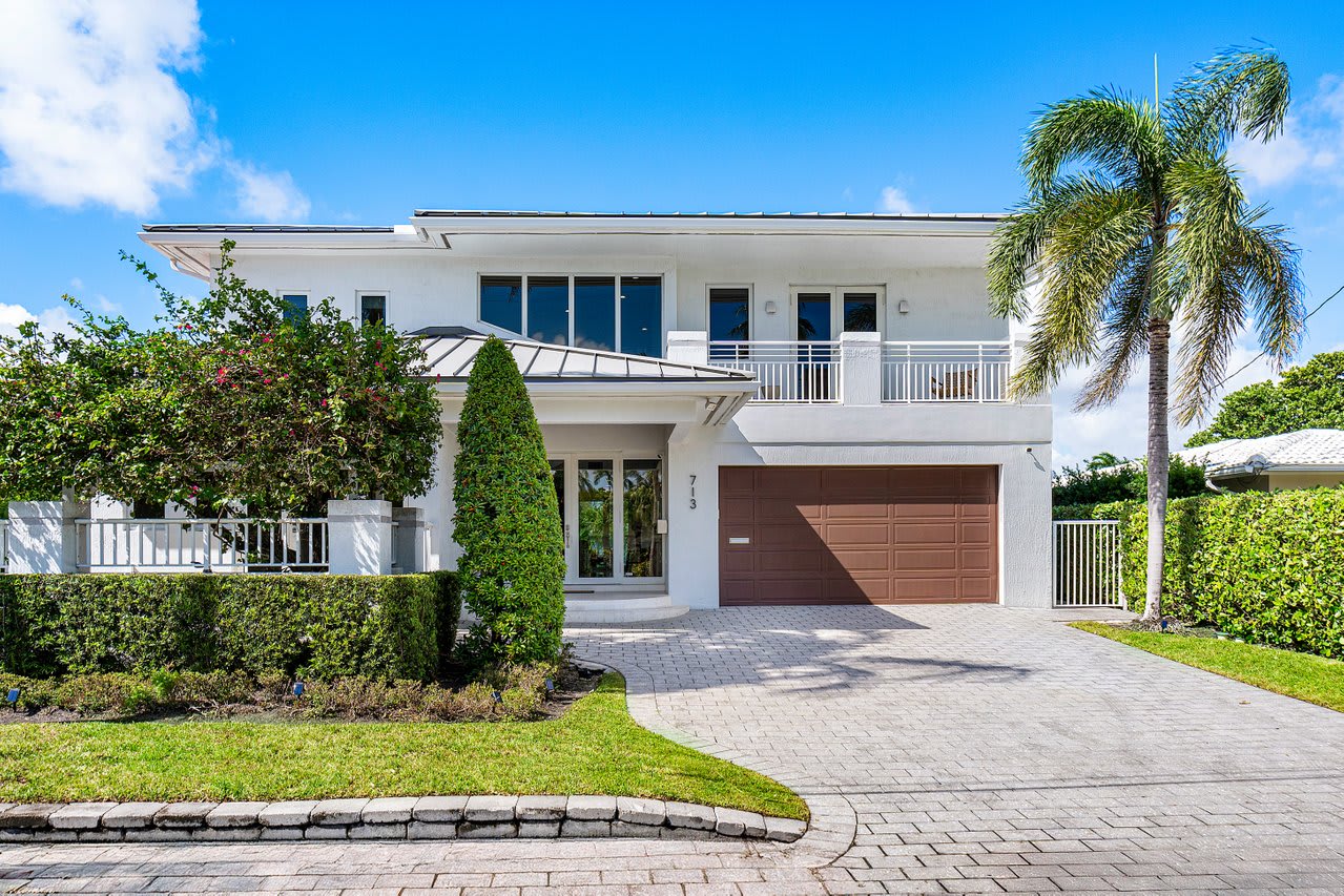 Step into elegance with a grand entryway framed by lush greenery and sophisticated architecture.