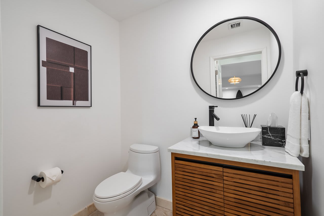 Simplicity meets sophistication. Featuring a natural wood vanity and chic circular mirror.