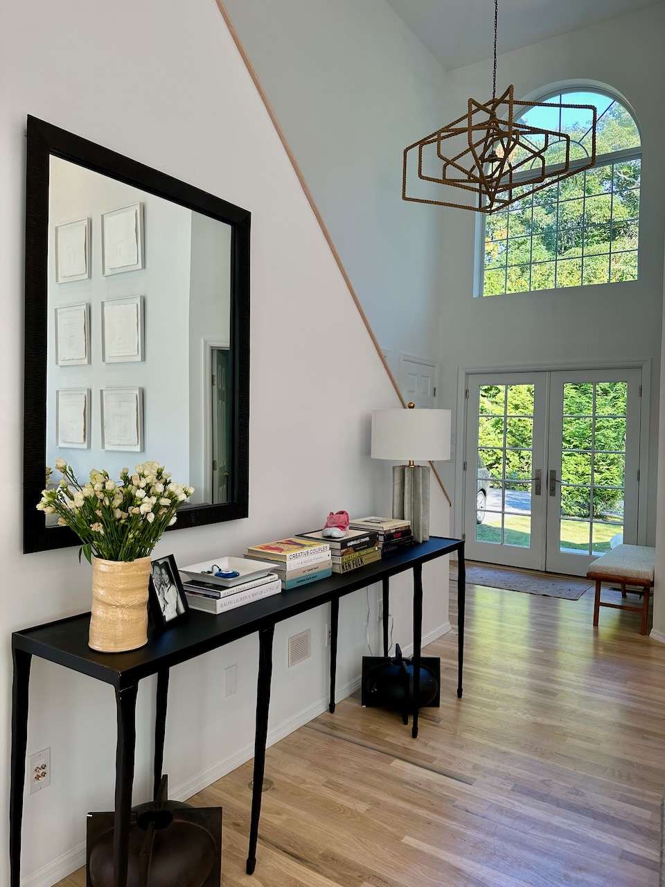Entry foyer with a console table, mirror, and a view through French doors to the yard.