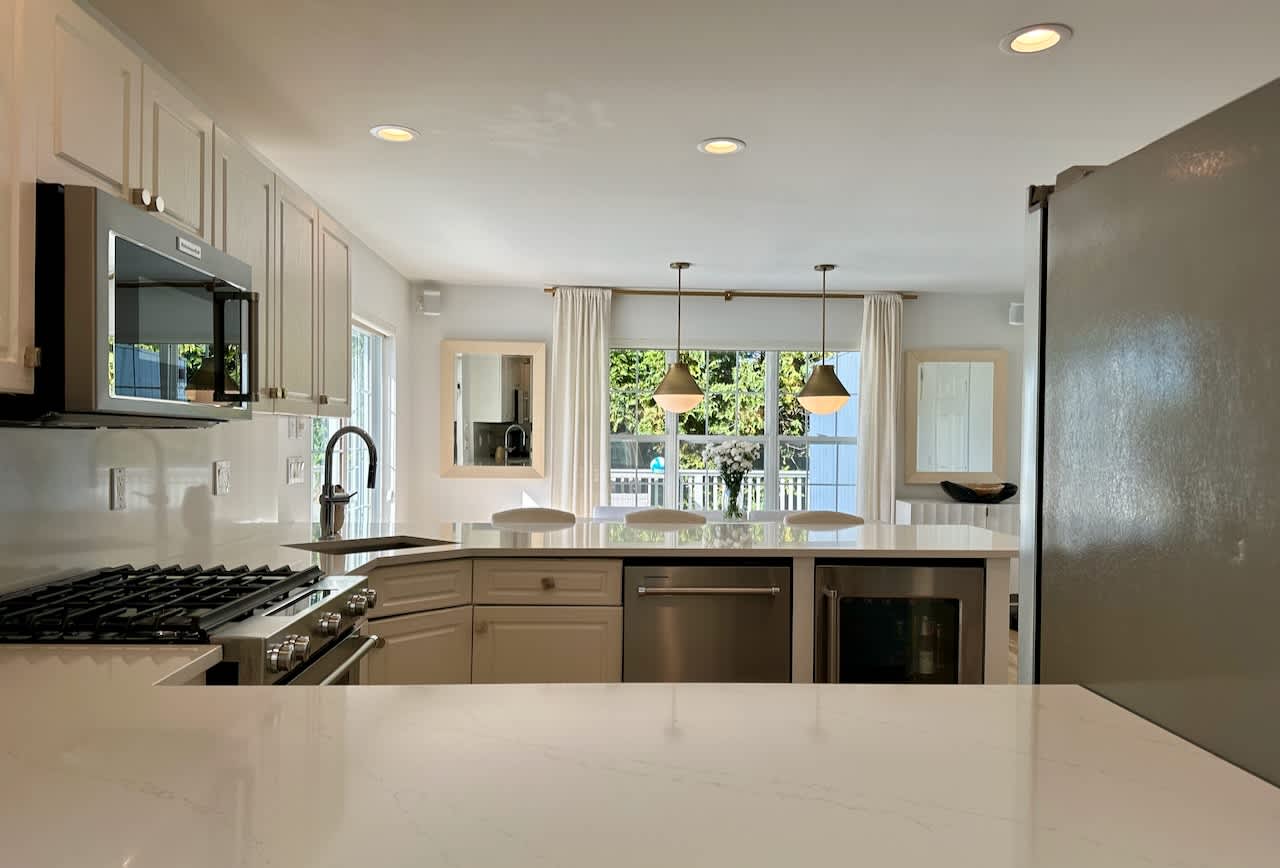 Kitchen with cream cabinetry, a gas cooktop, and a pass-through to the dining area.