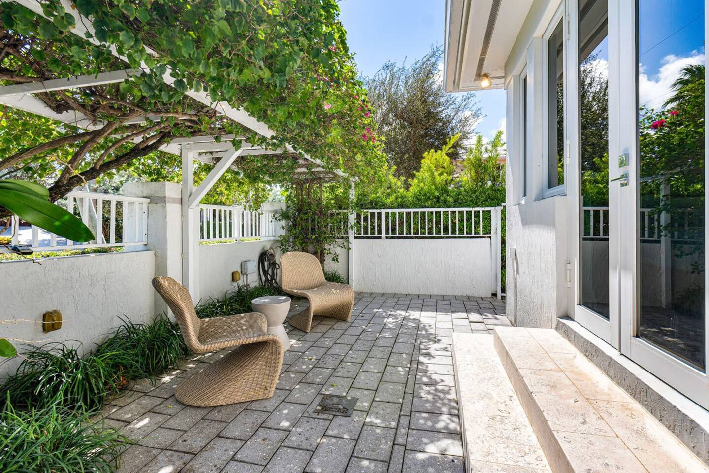Enjoy quiet moments on the private patio, surrounded by lush greenery and comfortable seating.
