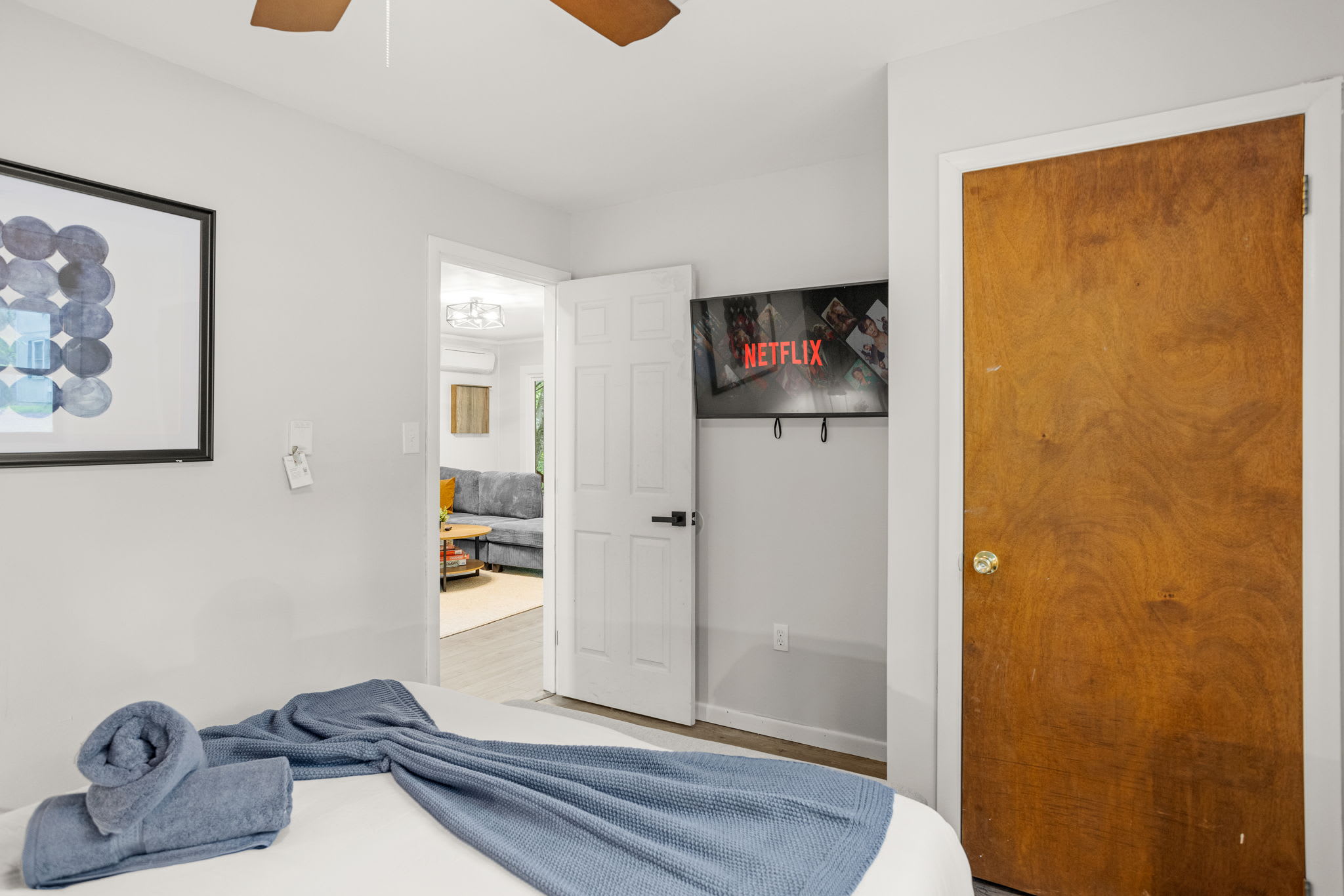 Bright & Airy Bedroom Retreat – A simple yet stylish bedroom with a mounted TV, warm tones, and a peaceful atmosphere.