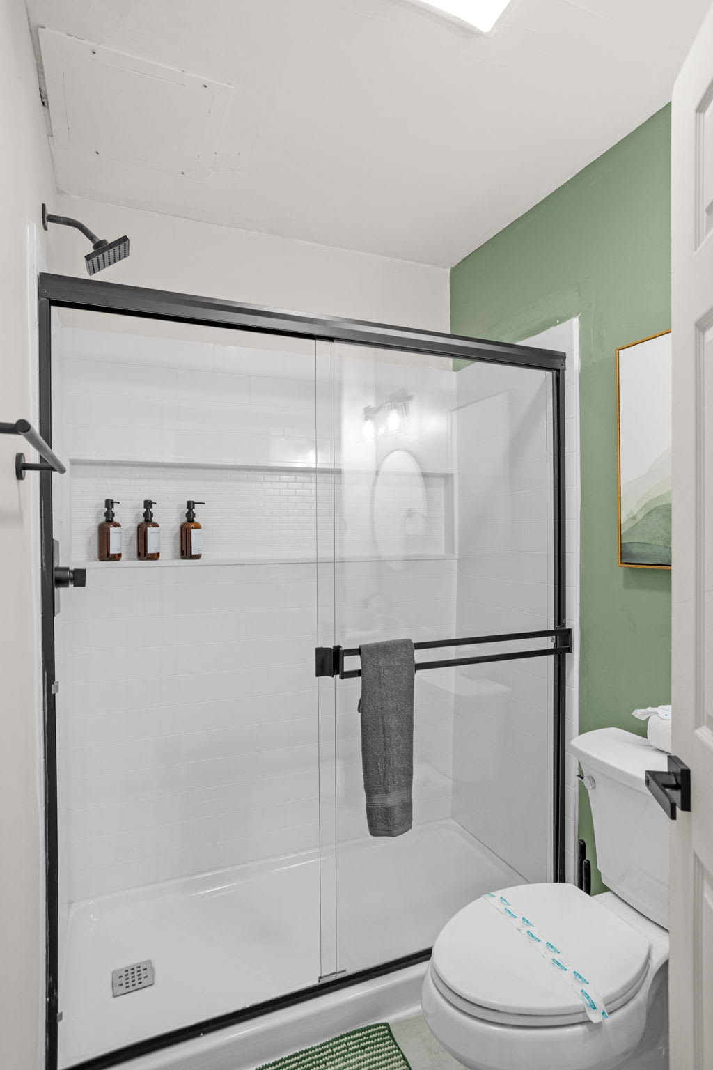 Sleek & Spacious Bathroom – A beautifully designed bathroom with a glass-enclosed shower, black fixtures, and a fresh, modern aesthetic.