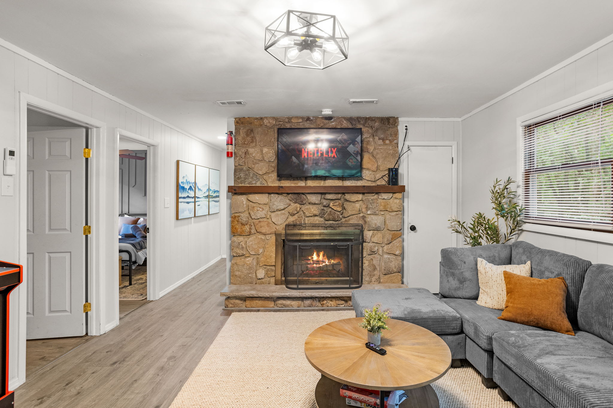 Elegant Fireplace with Netflix Ready – A rustic stone fireplace with a mounted TV, setting the perfect cozy ambiance for a movie night.