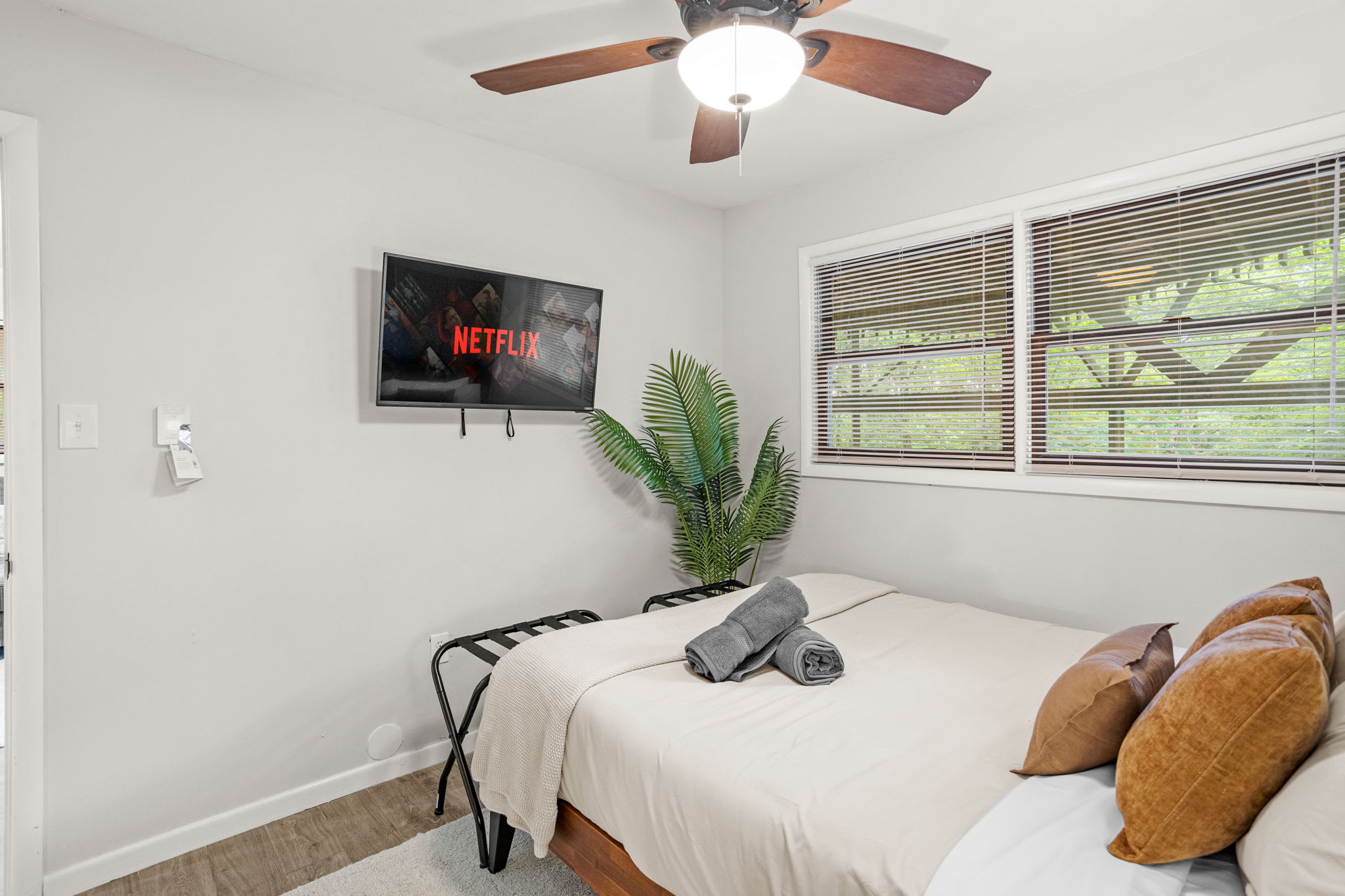 A glimpse into a well-lit, contemporary bedroom with soft bedding and unique wall accents.