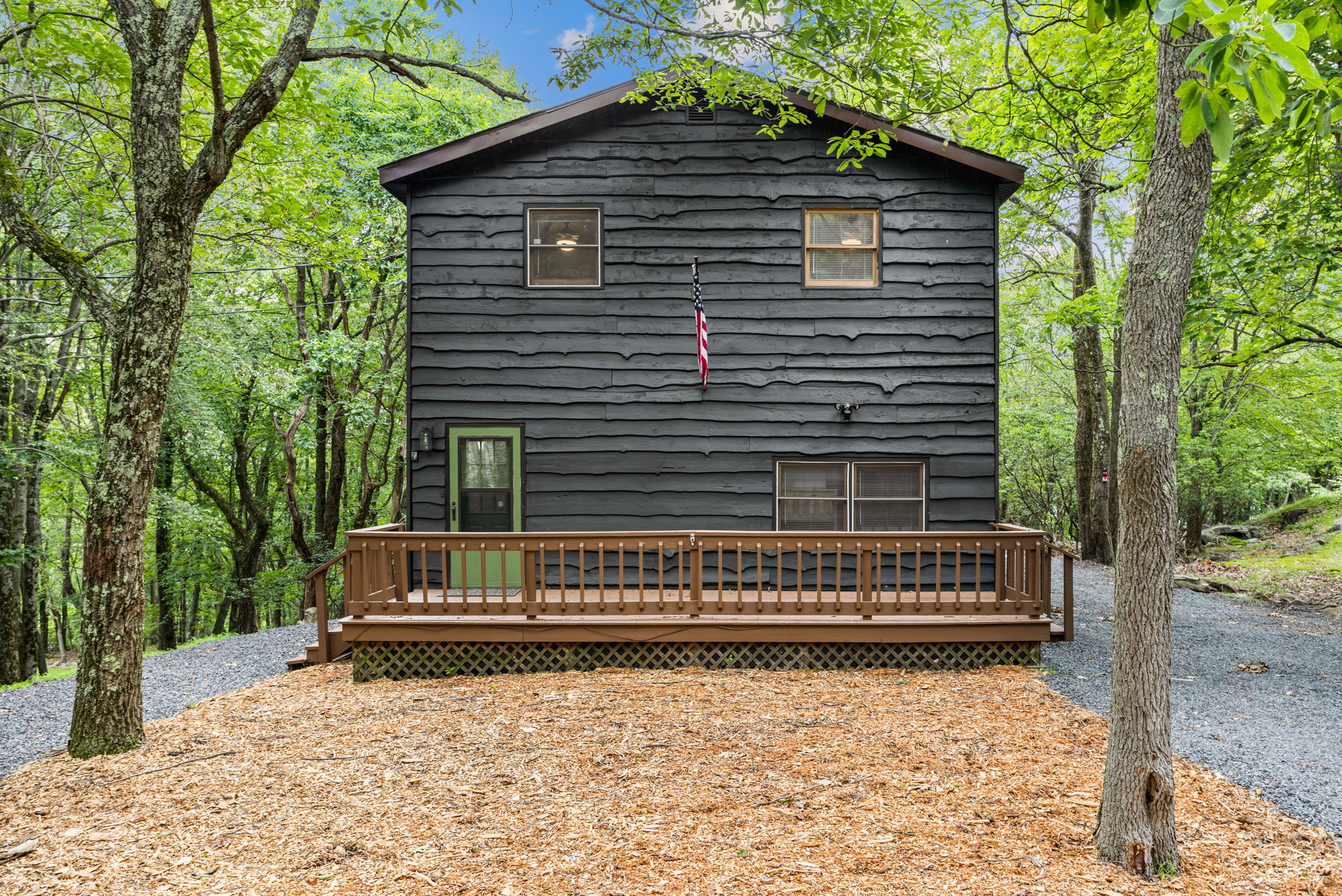 A charming black house nestled among lush greenery, offering a secluded and peaceful retreat.