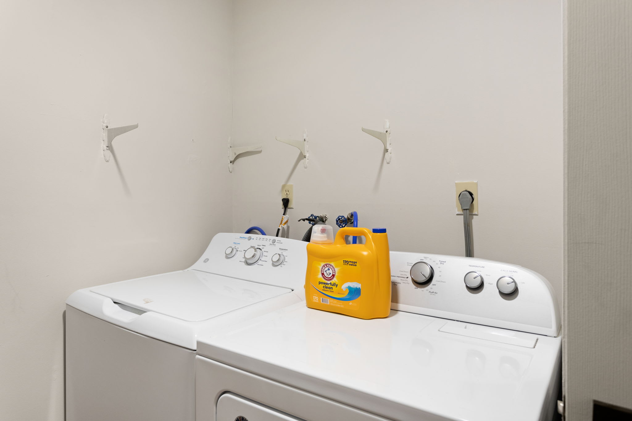 A functional laundry space featuring a washer and dryer setup with bright lighting.