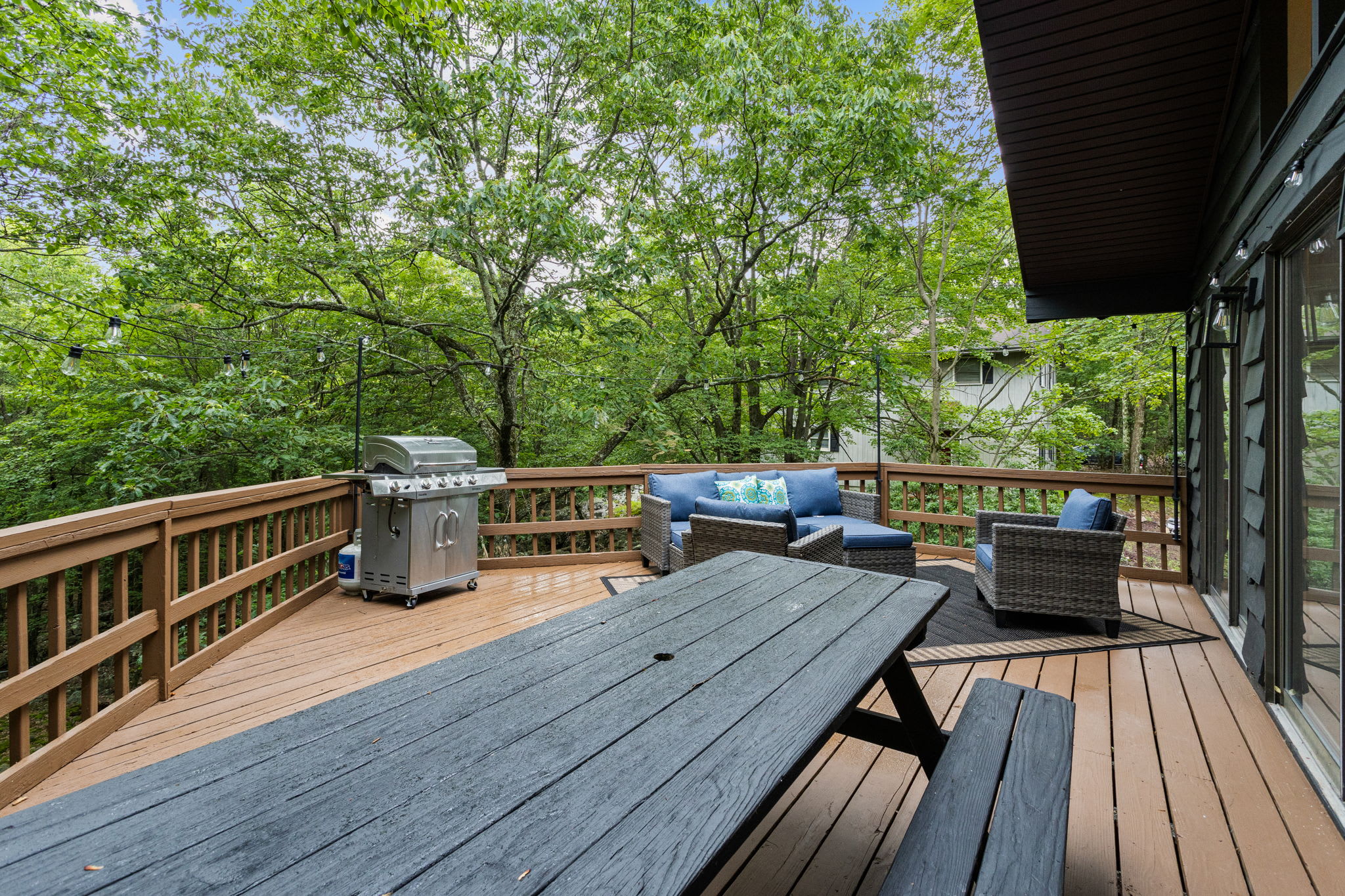 Expansive Deck with Picnic Seating – A beautifully designed outdoor deck with a large picnic table, scenic views, and a grill for enjoying outdoor meals.