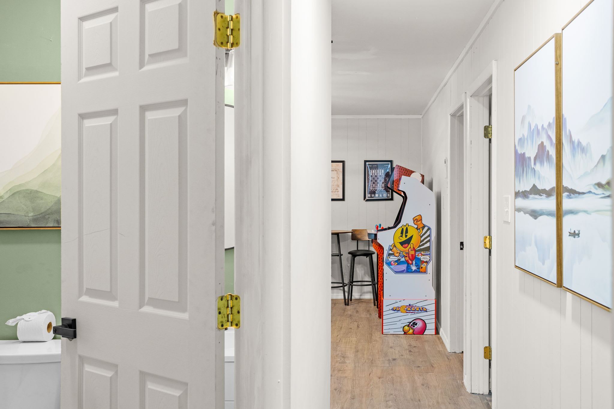 A bright and inviting hallway leading to a fun entertainment space with classic arcade games.