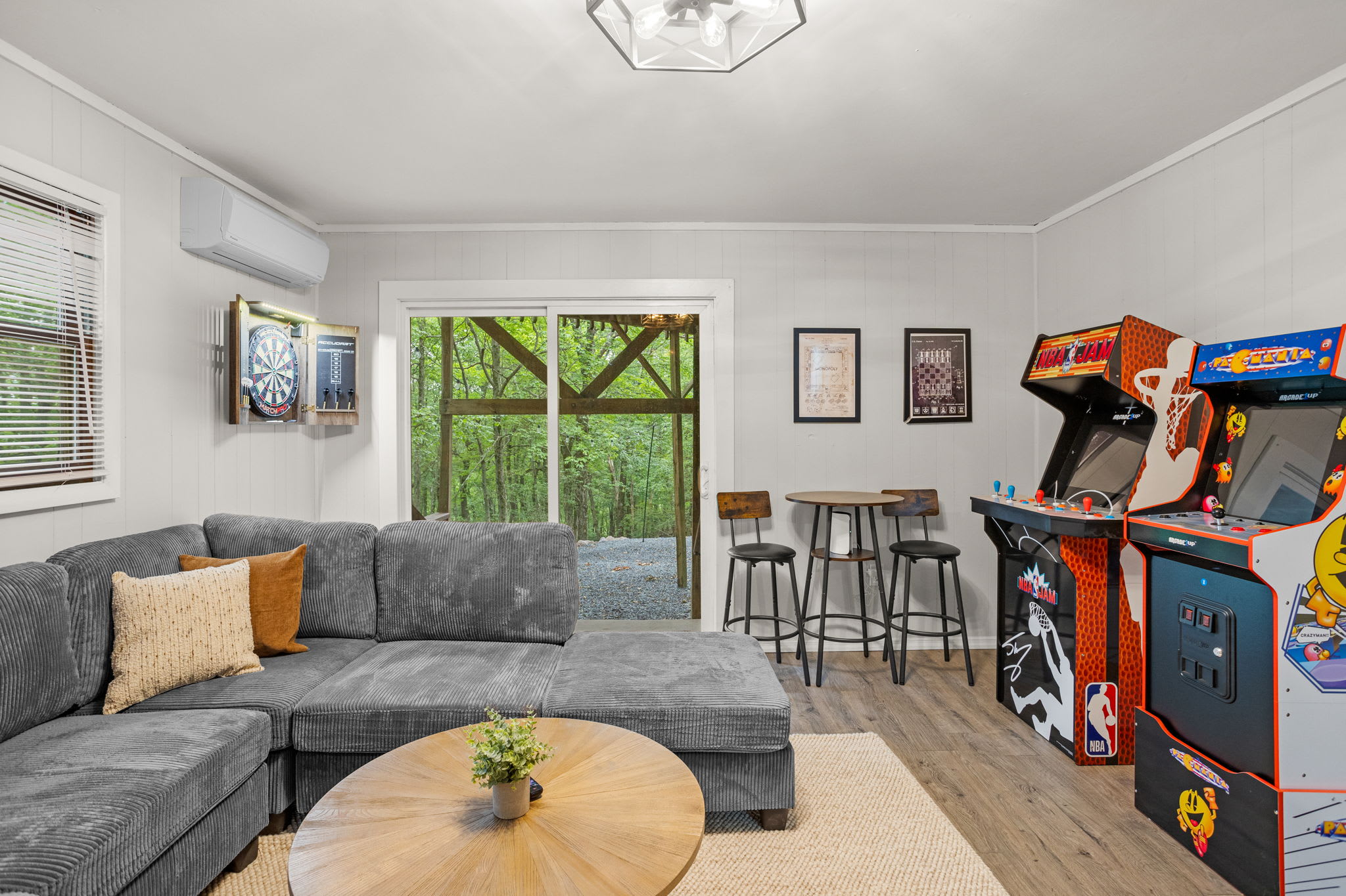 Lounge & Game Room - A spacious living area with a large sectional sofa, arcade machines, and framed artwork for a blend of comfort and fun.