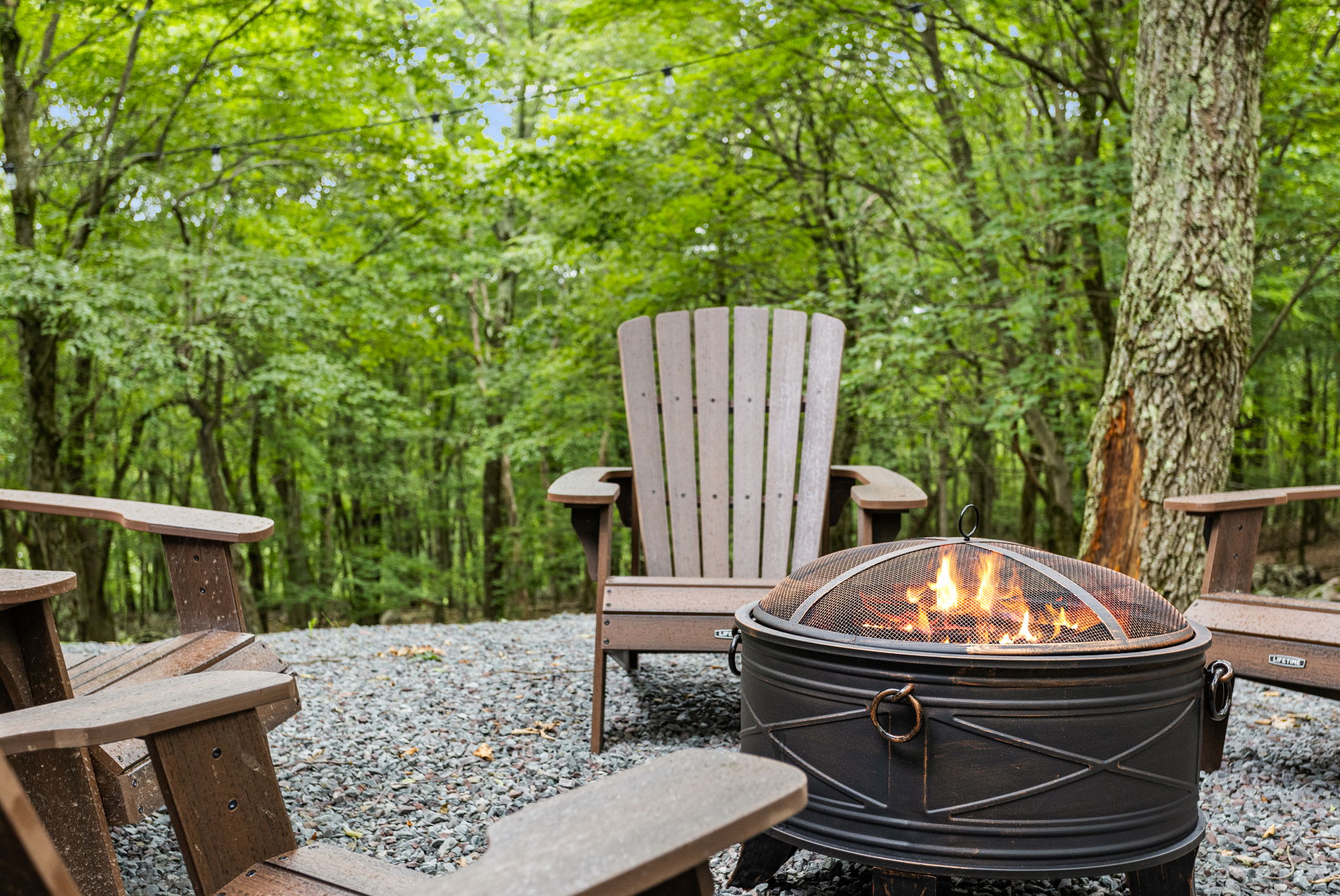 Fire Pit Gathering Spot - A serene outdoor fire pit surrounded by Adirondack chairs, offering the perfect spot for evening relaxation.