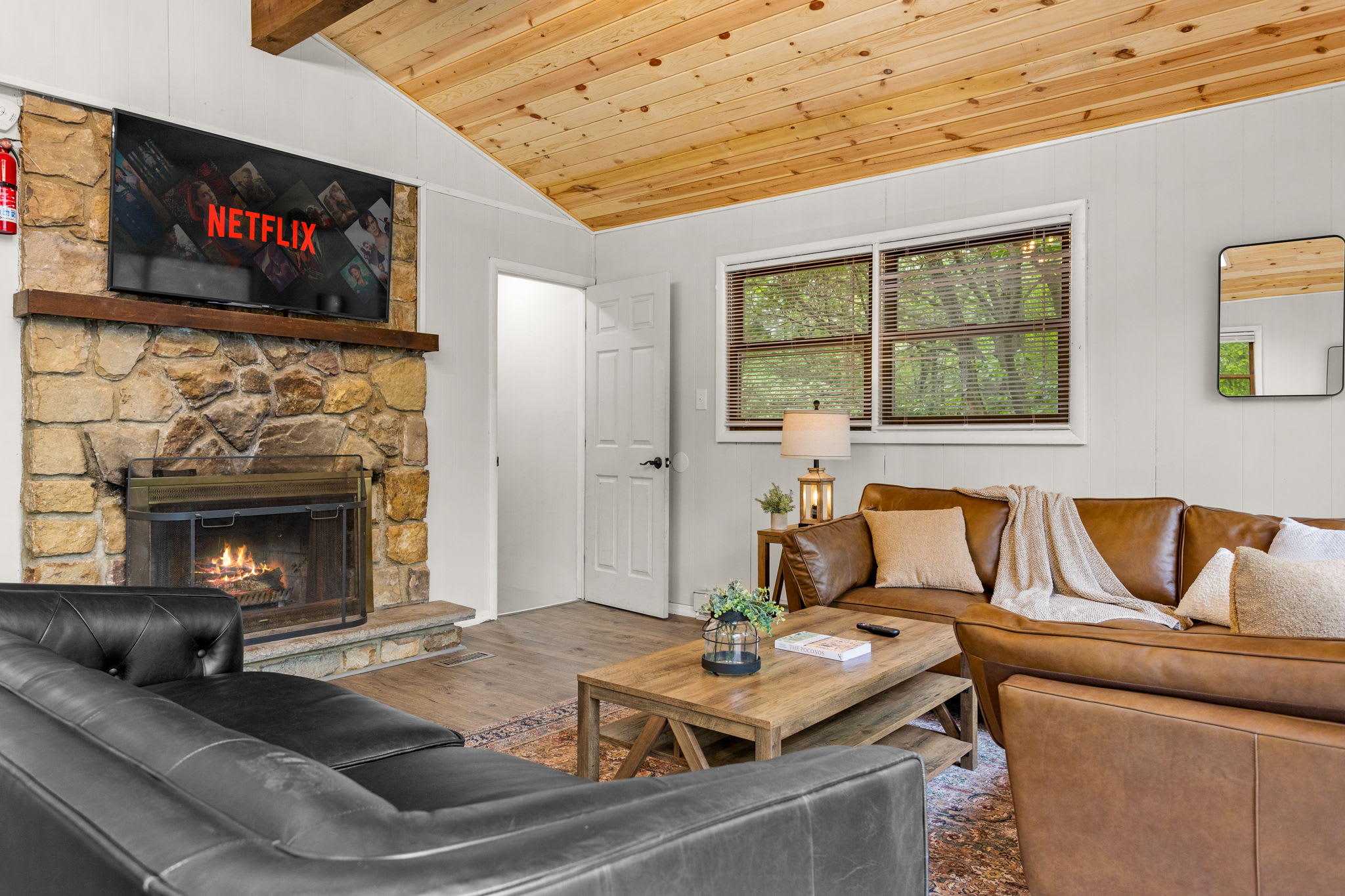 Rustic Fireplace Lounge – A stone fireplace with a mounted TV, paired with comfortable seating, creating a cozy entertainment area.