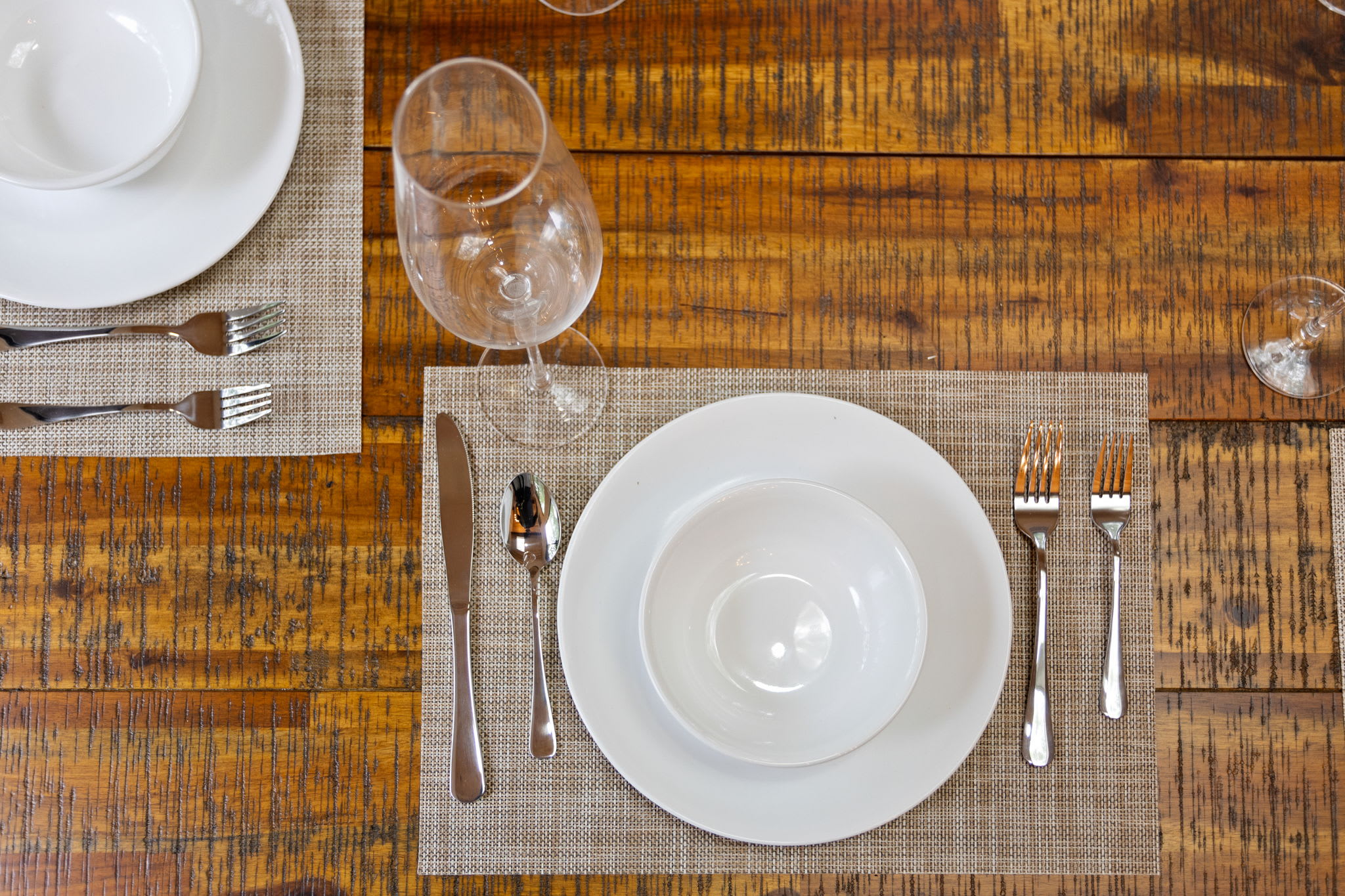 A close-up of a beautifully set dining table on a rustic wooden surface, perfect for intimate meals.