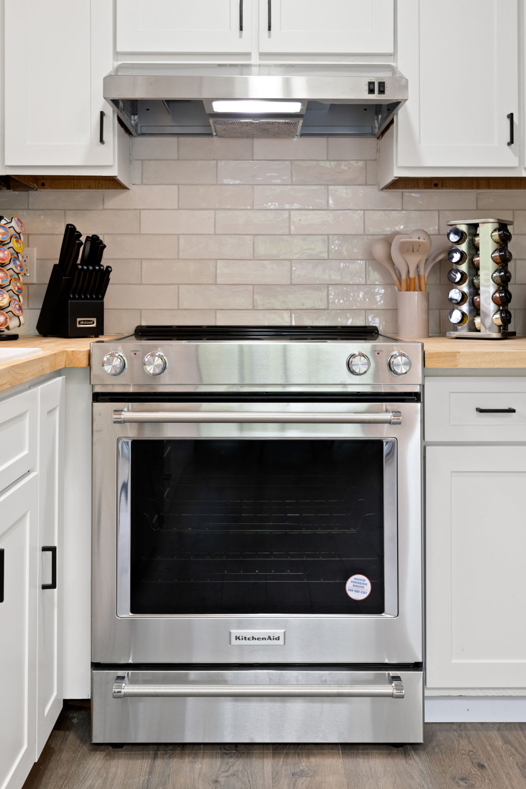 Stainless steel stove and oven with a modern black backsplash, giving the kitchen a high-end feel.