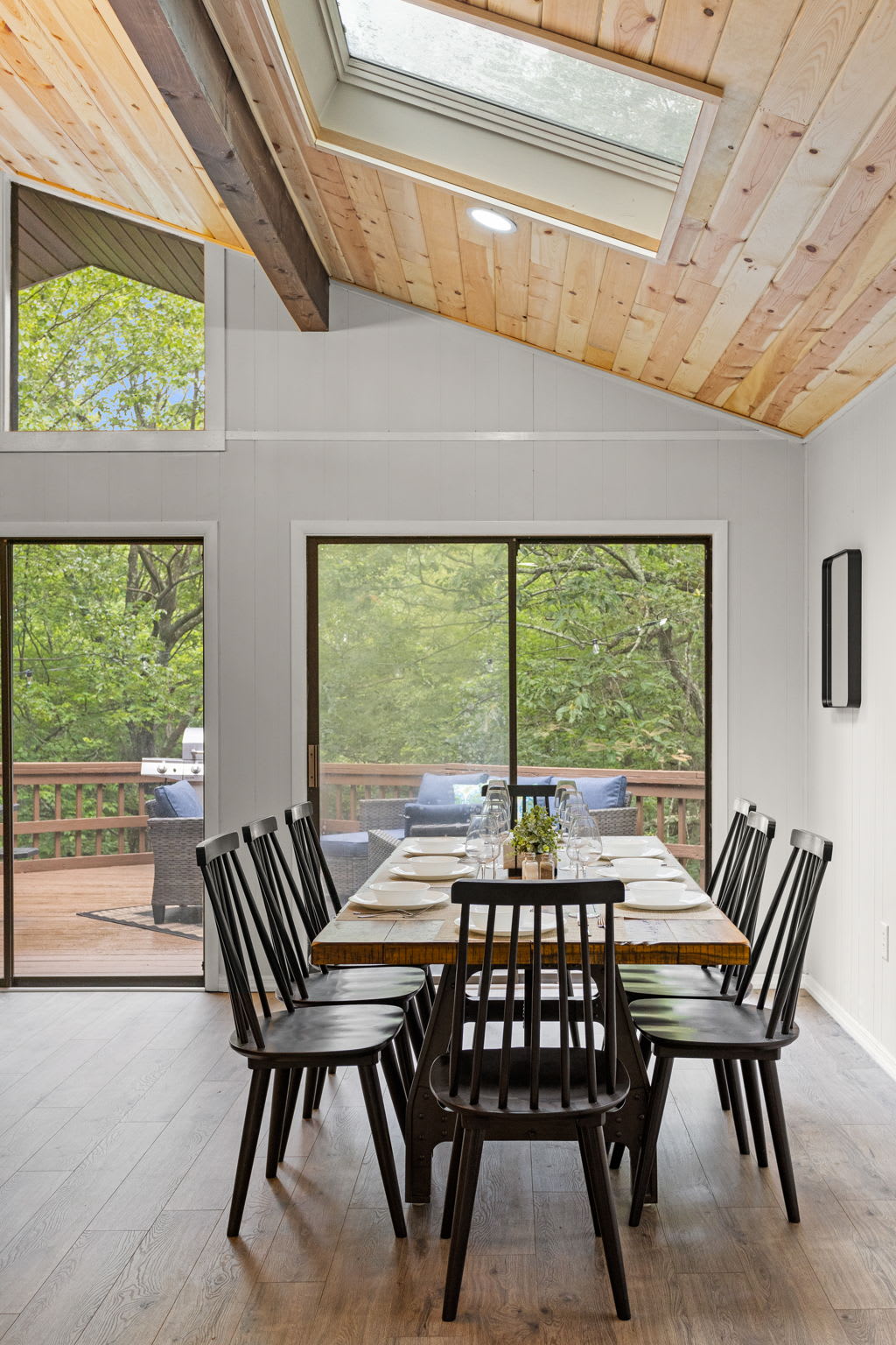 Elegant Dining Area – A sophisticated dining space with high ceilings, large windows, and a view of the lush outdoors.