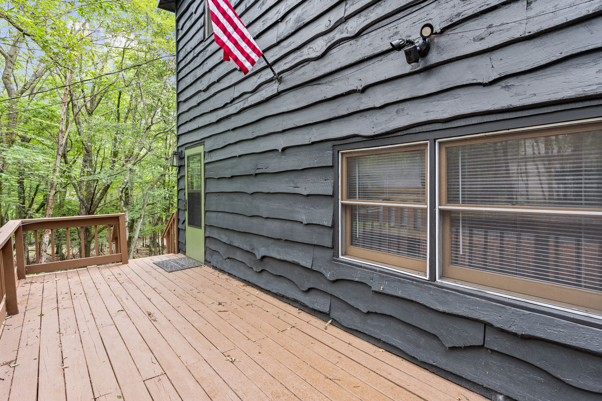 The deep charcoal wood siding with a striking green door creates a cozy yet modern aesthetic.