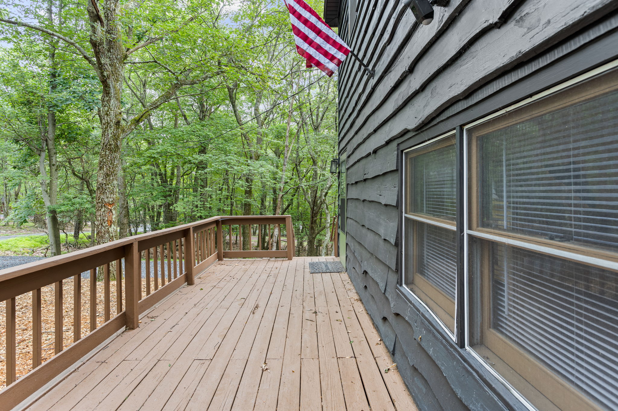 The deck extends alongside the house, offering plenty of room for relaxation while being immersed in nature.