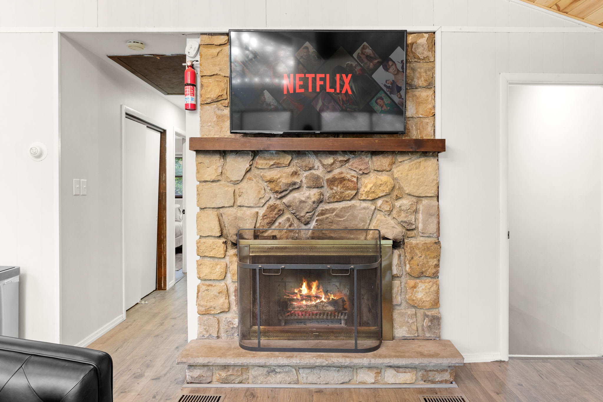 A stone-clad fireplace with a mounted TV makes for the perfect cozy movie night spot.