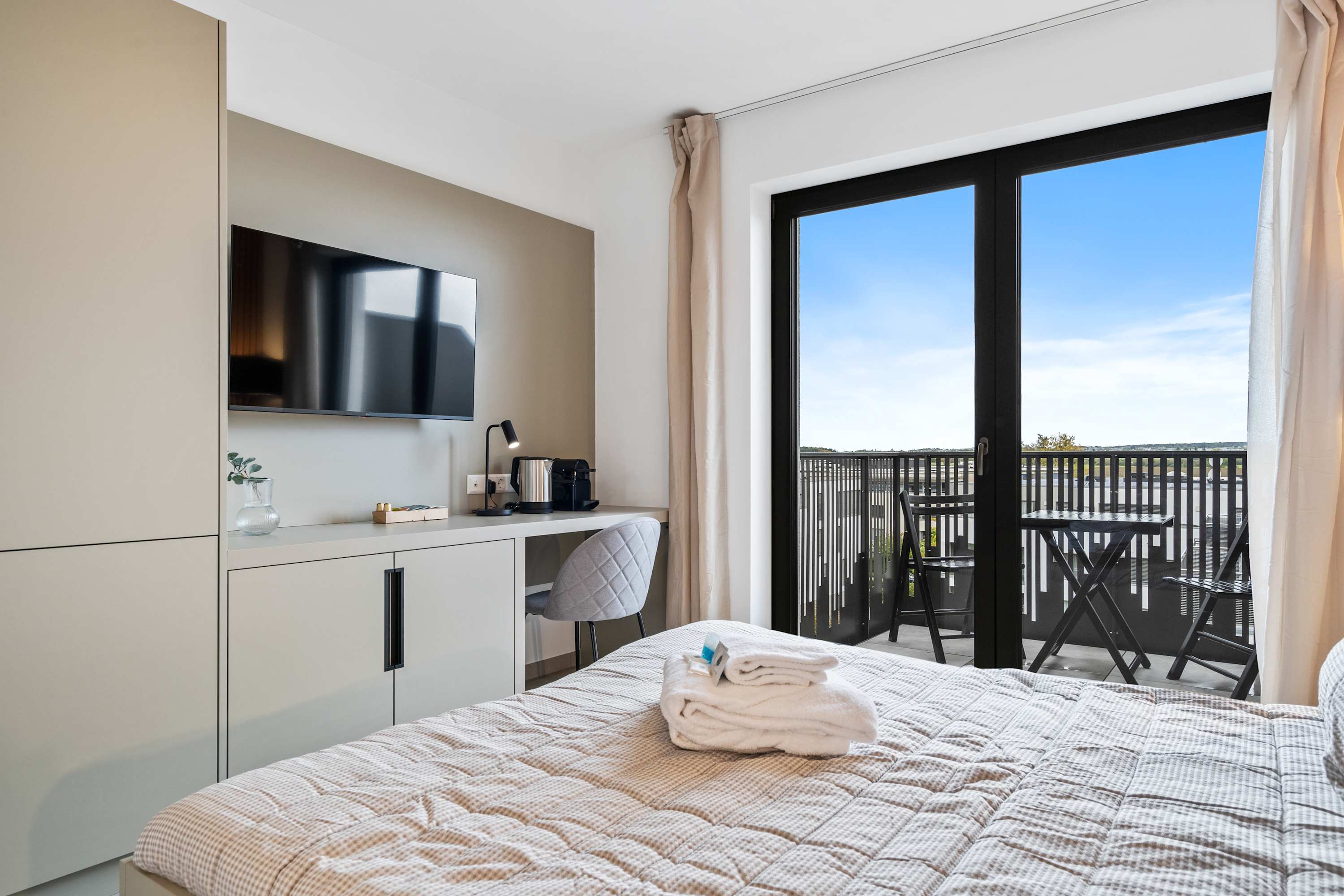 Private Balcony with Scenic Views – Step out to enjoy fresh air and city views, complete with seating for two.