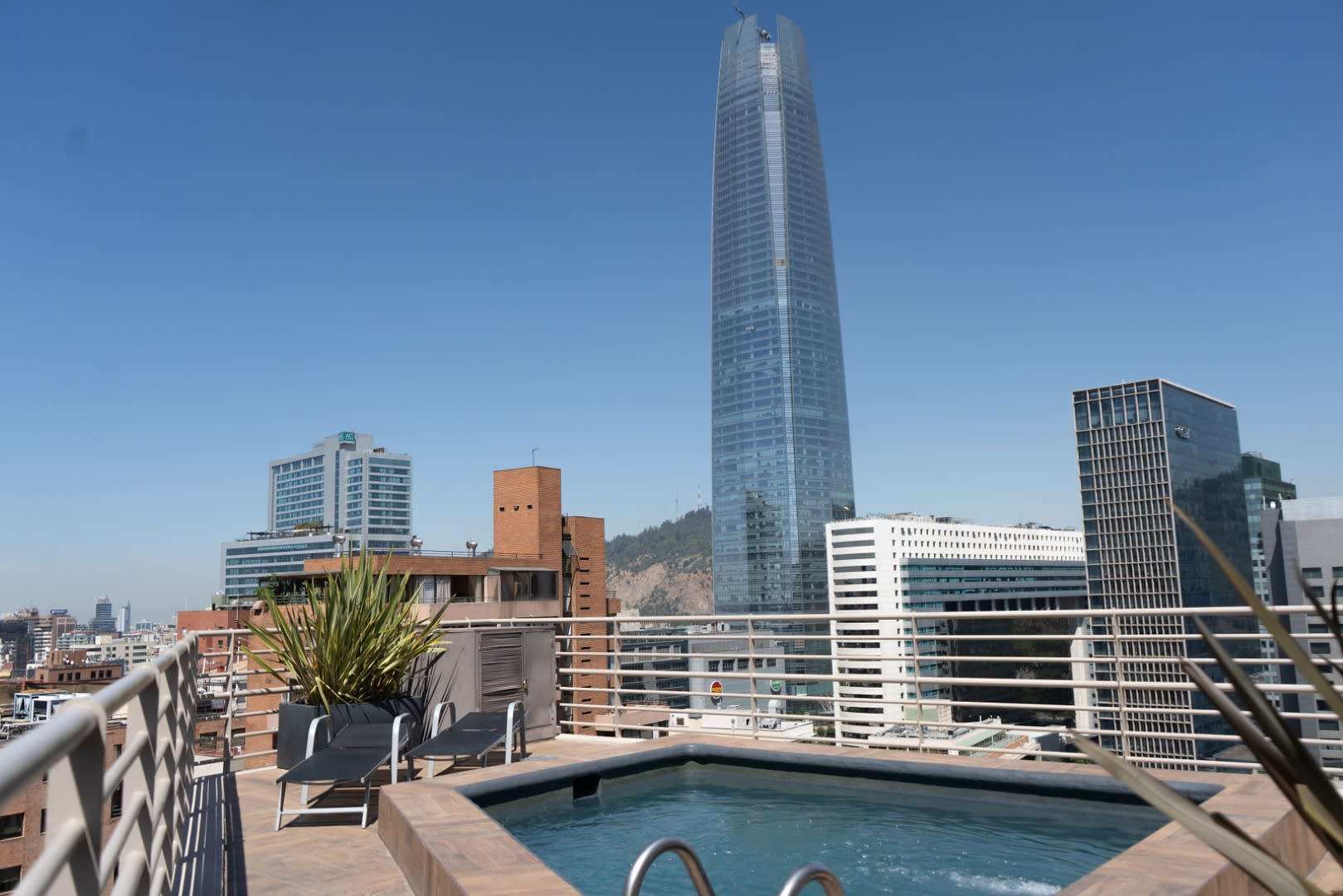 Enjoy a refreshing dip in the rooftop pool with stunning cityscape views of Santiago's skyline.