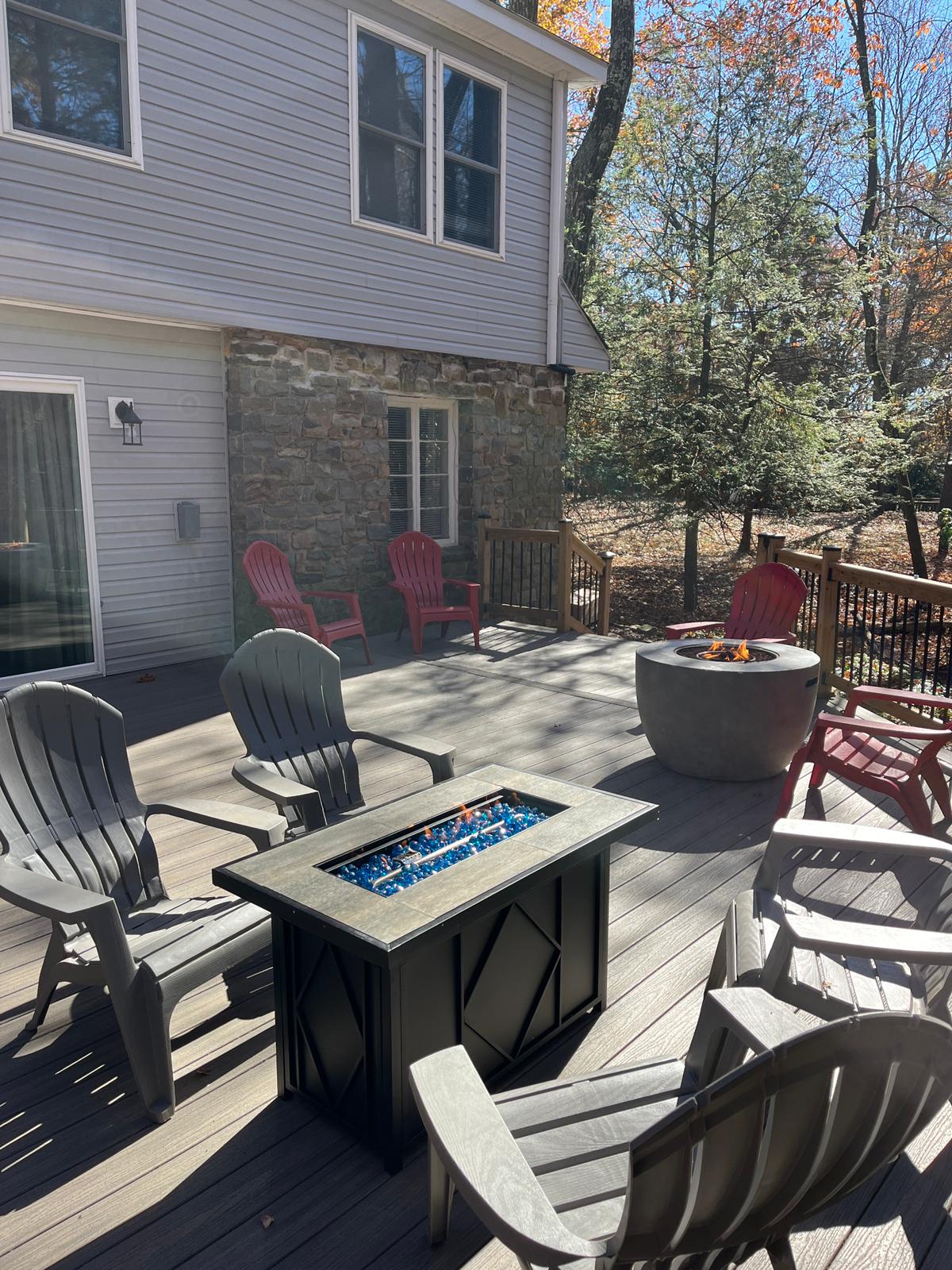 This spacious deck offers multiple seating areas, a stylish fire table, and a beautiful woodland backdrop ideal for relaxing afternoons or lively evening gatherings.