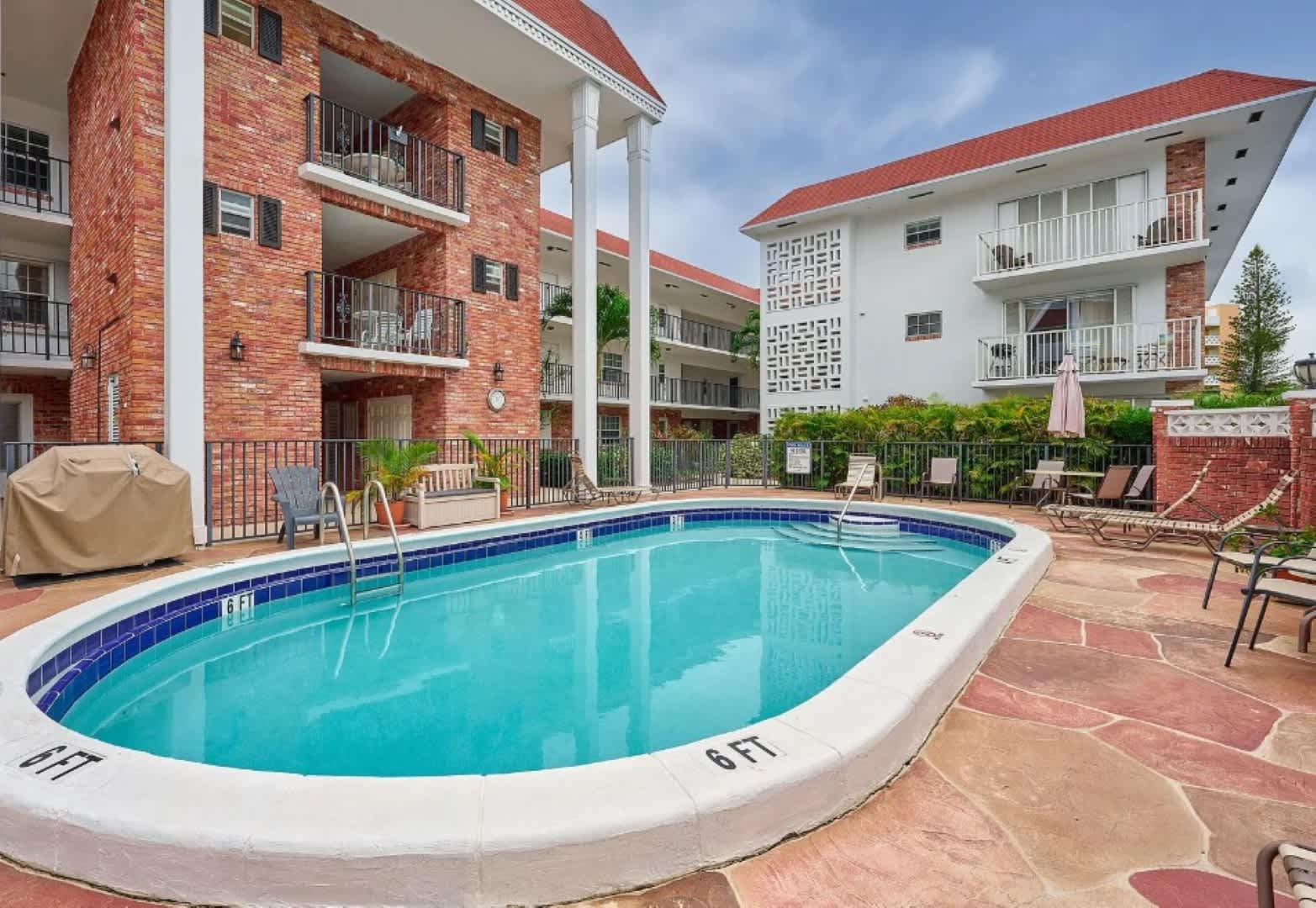 Relax by the inviting pool in this charming brick courtyard, perfect for a refreshing swim or lounging in the sun.