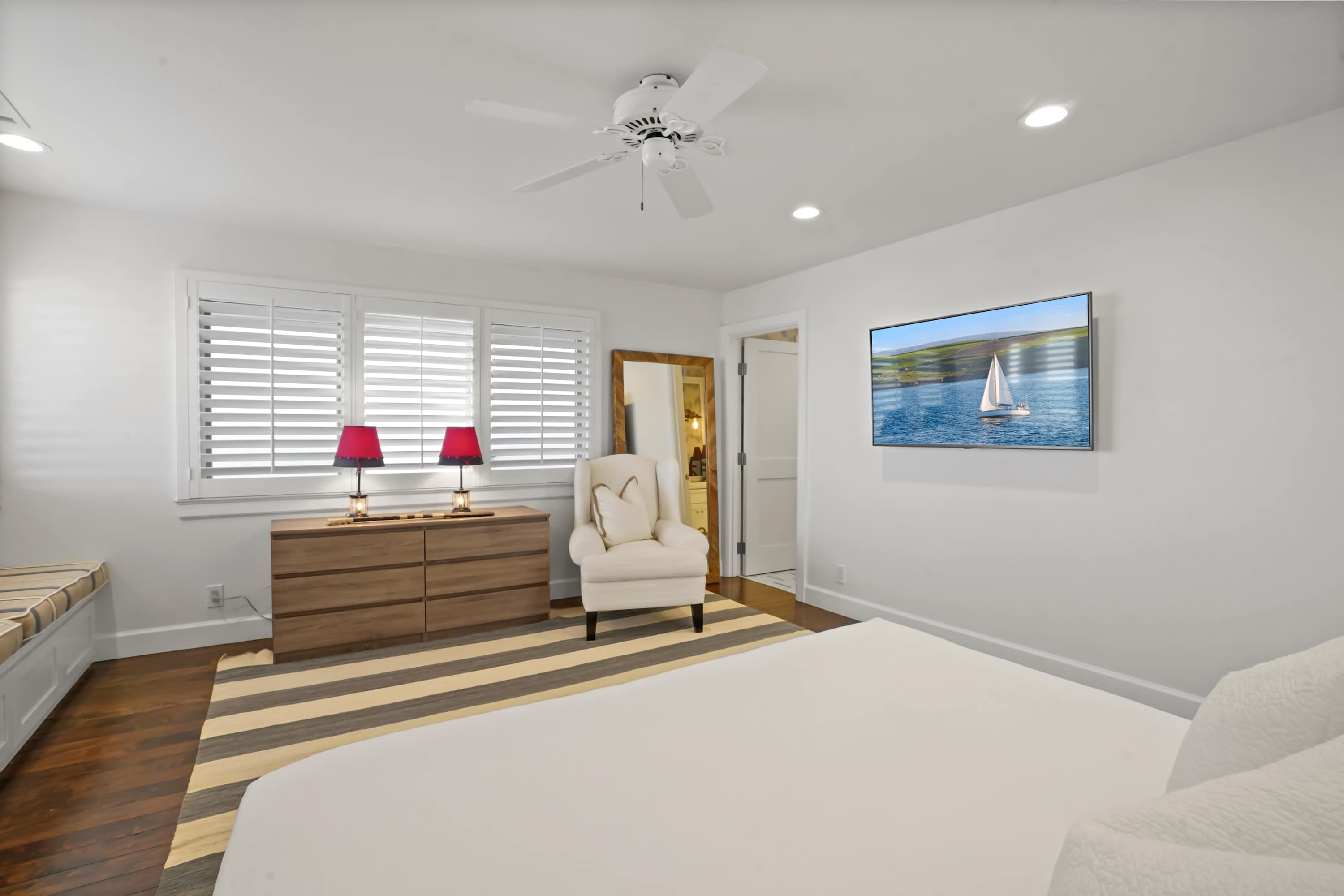 Featuring plush bedding, ceiling fans, natural textures, room darkening shades, and serene coastal decor.