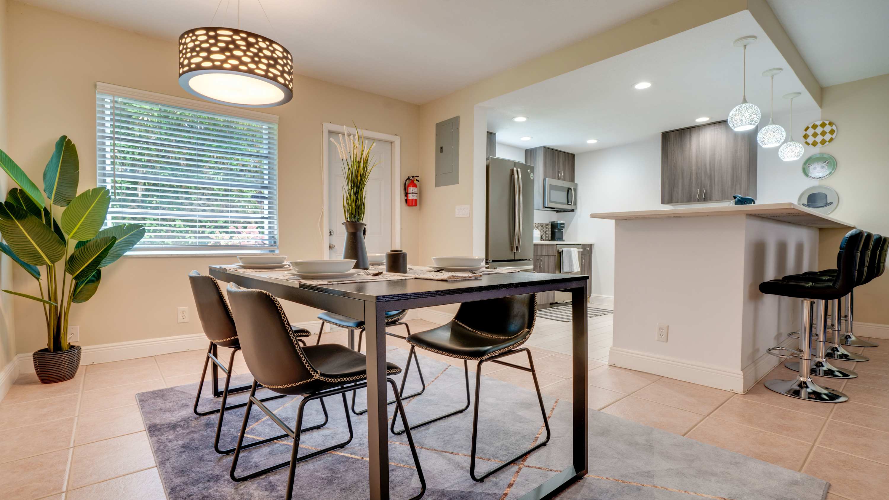 Enjoy meals in a stylish dining area with modern decor and an open kitchen view, perfect for gatherings.