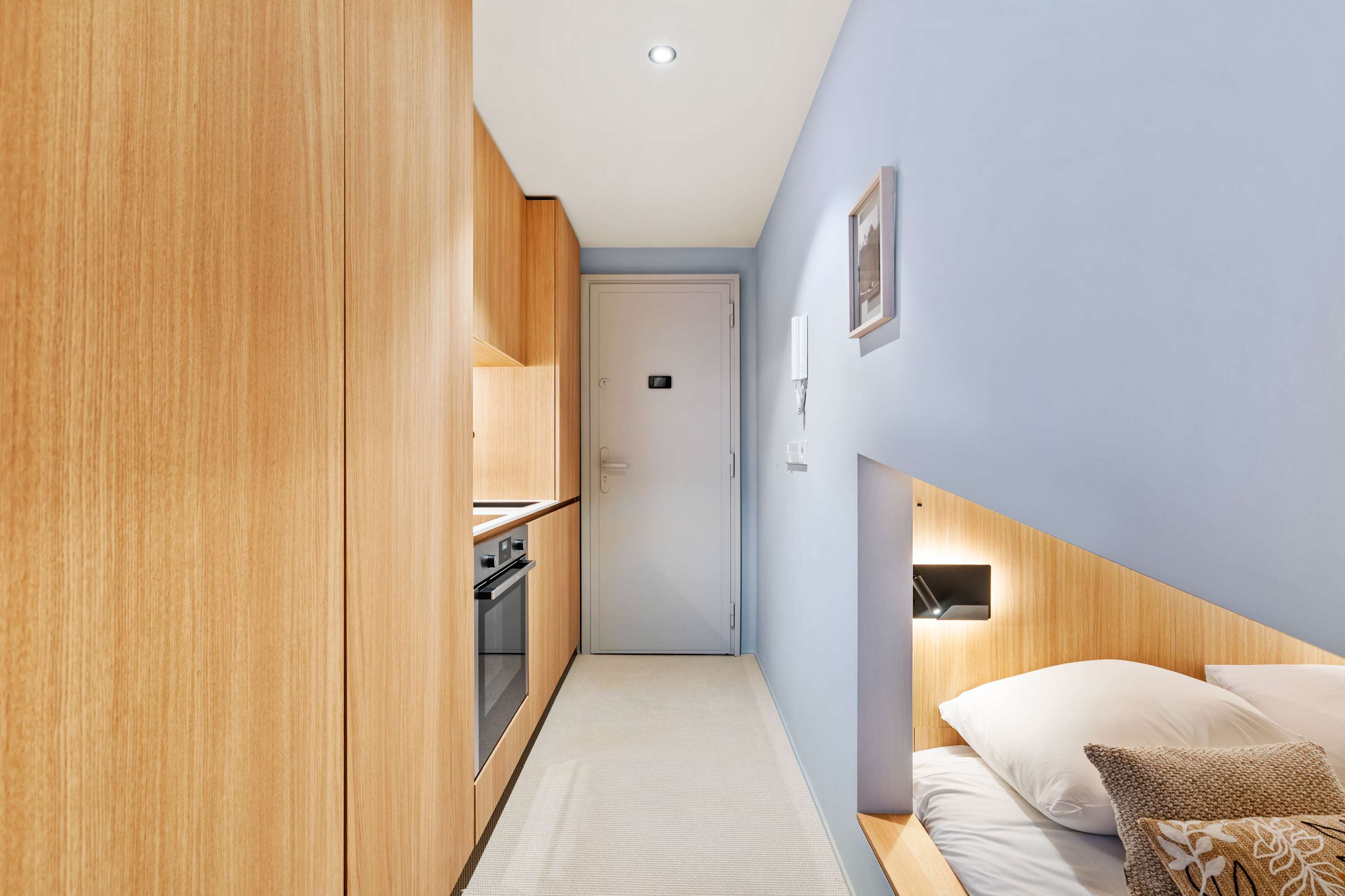 Streamlined Layout – A view of the fully integrated kitchenette leading to the cozy bedroom area.