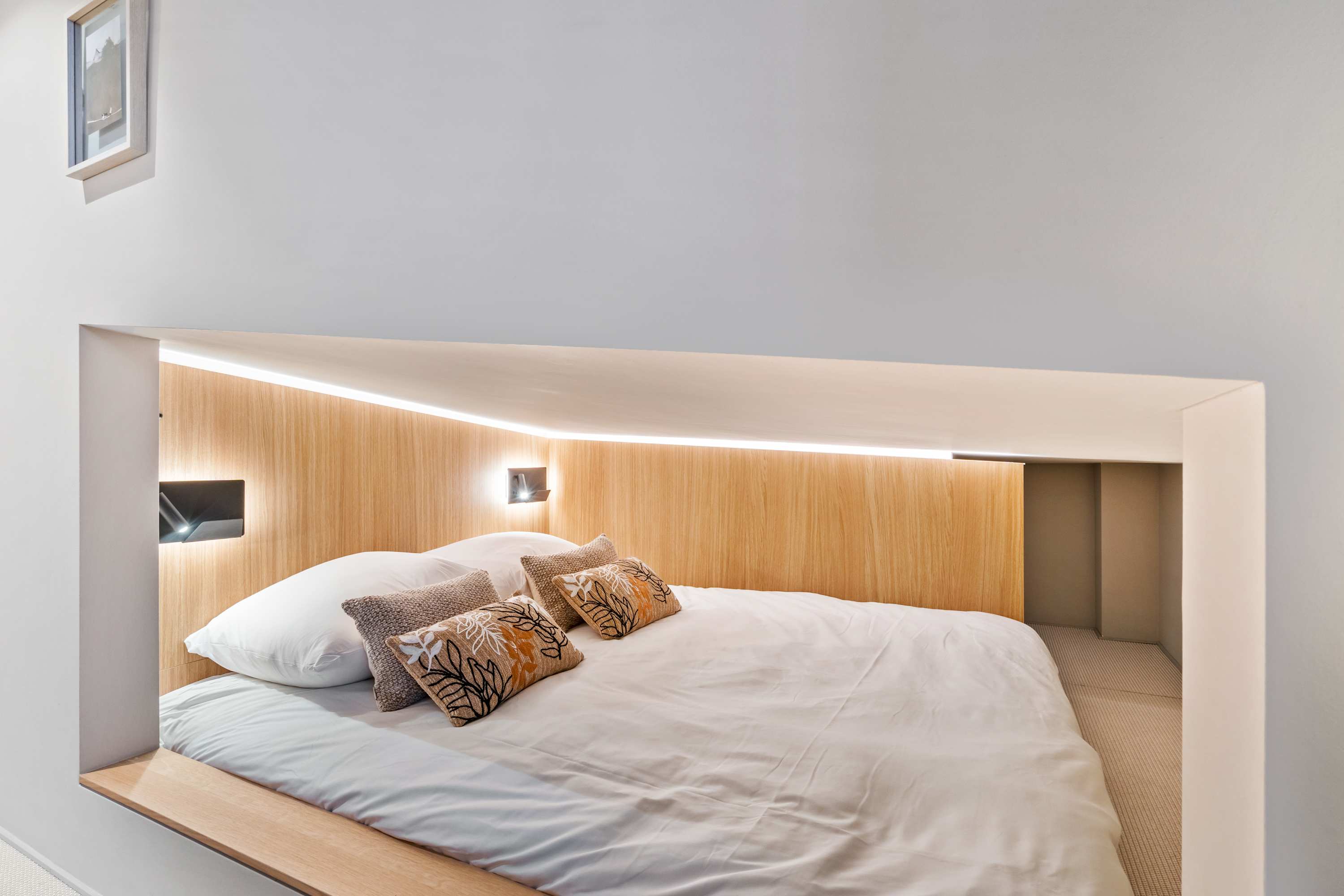 Stylish Sleeping Area – Relax in a queen-sized bed with soft linens and calming lighting.