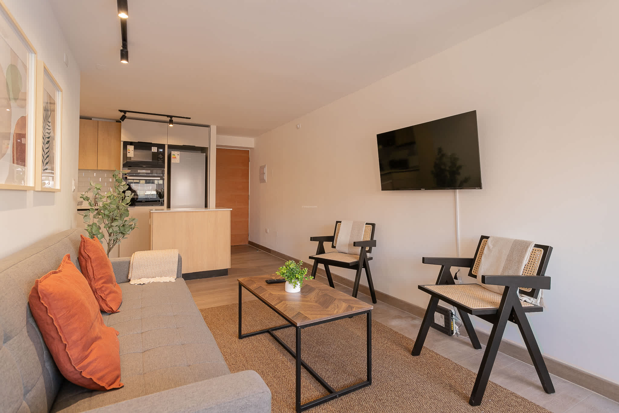 Cozy living room with modern decor and open kitchen, perfect for relaxing after a day of exploring.
