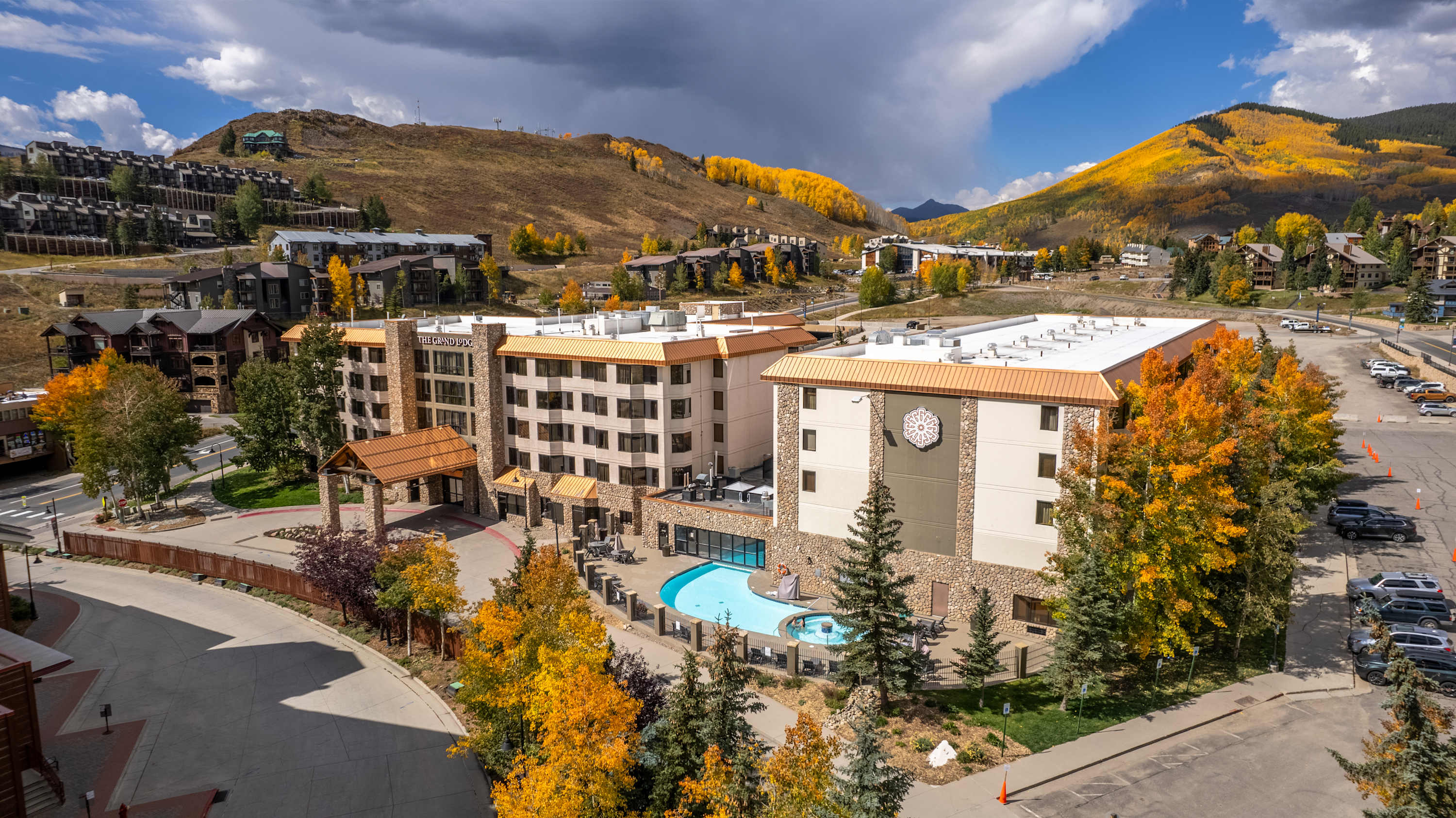 Slope-side condo hotel at the base of a ski mountain with snow-covered slopes in the background
