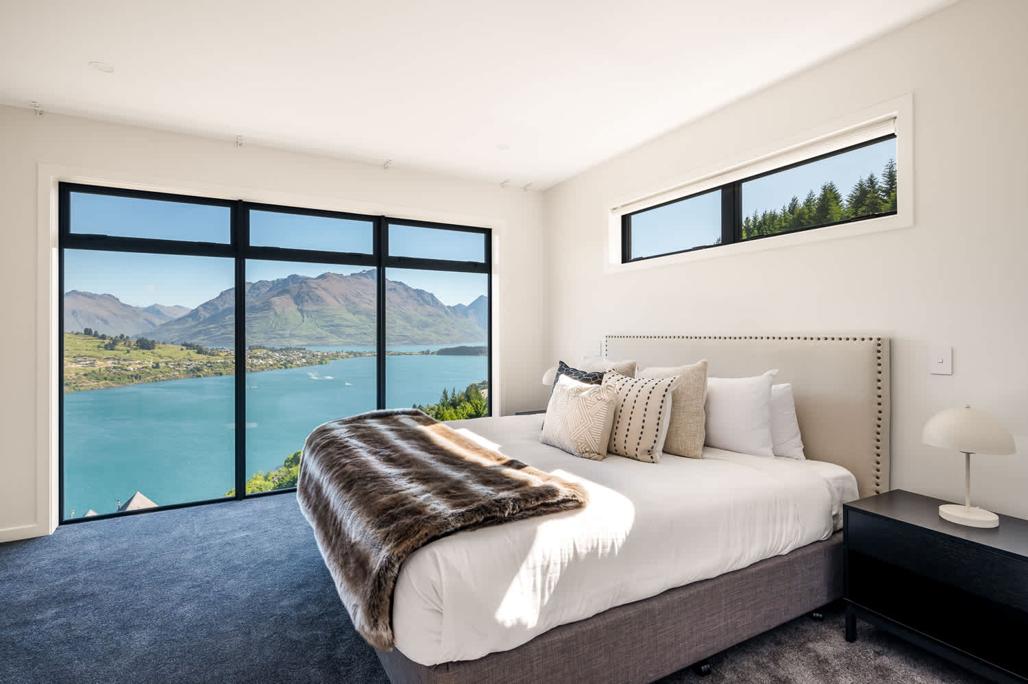 Wake up to breathtaking views of Lake Wakatipu and the surrounding mountains in this beautifully appointed bedroom in Queenstown.