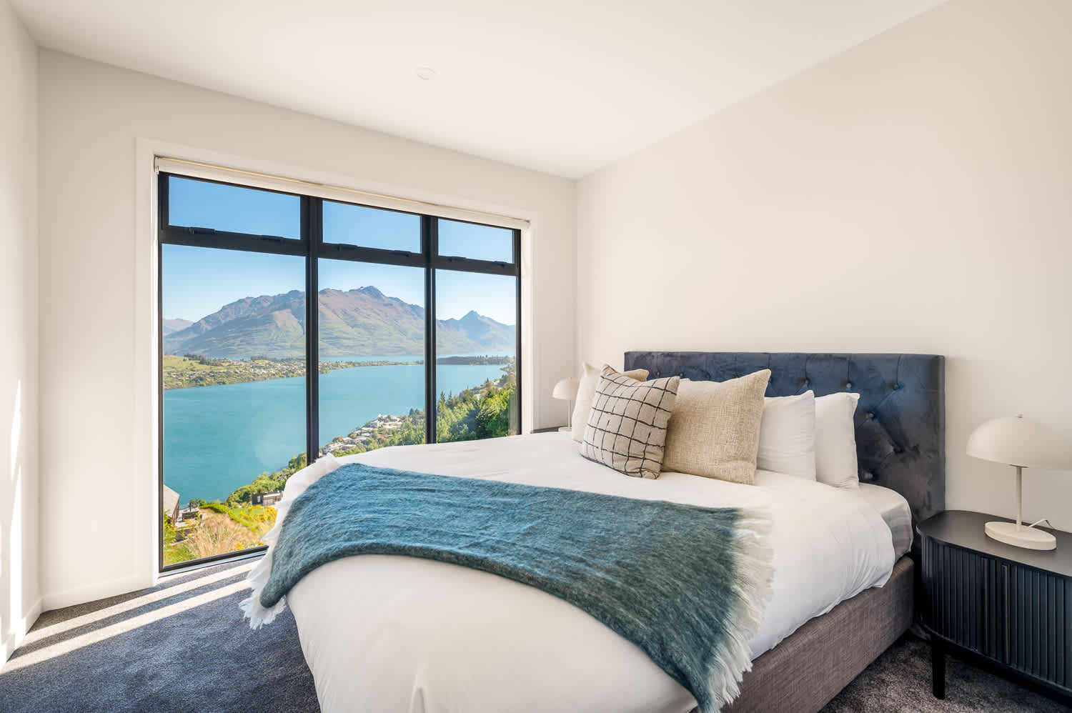 This room is flooded with natural light from large windows, providing an uninterrupted view of the serene lake and majestic peaks.