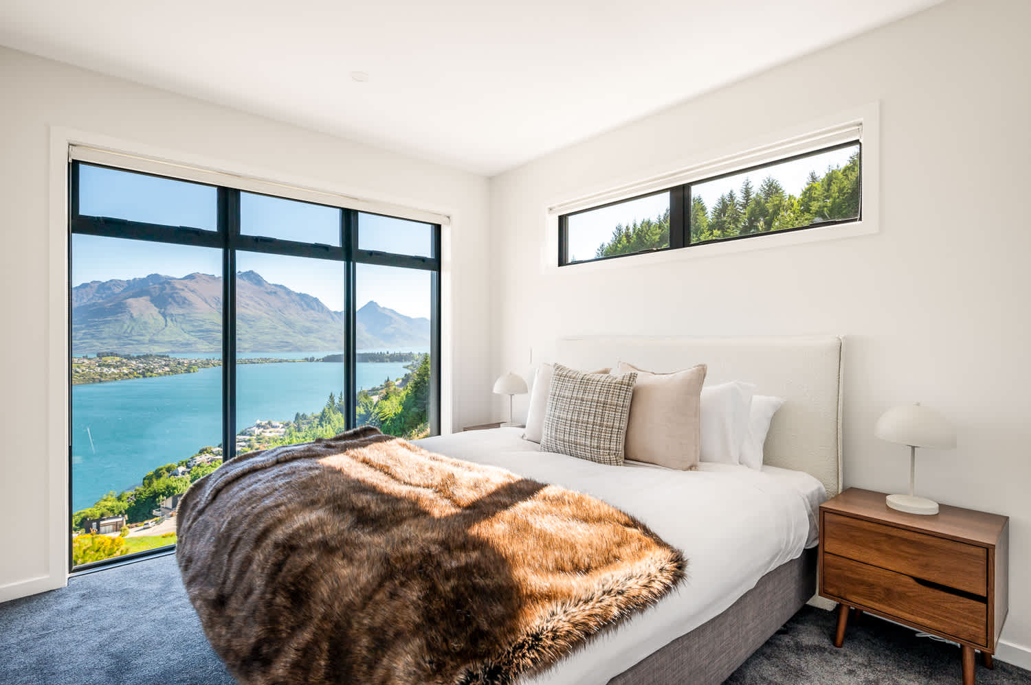 The spacious room is elegantly furnished, with plush bedding and tasteful decor that complements the stunning natural surroundings. 