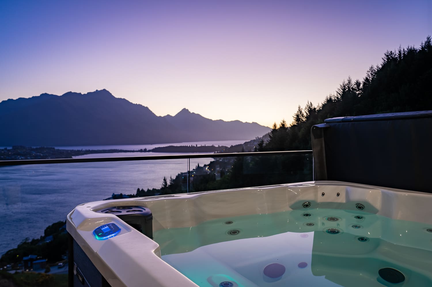 Soak in a private outdoor bathtub with stunning views of Lake Wakatipu and the surrounding mountains in Queenstown.