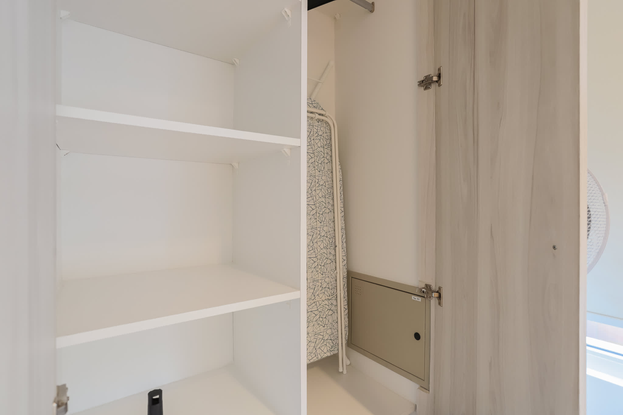 Spacious closet with ample storage and an ironing board, perfect for organizing your stay.