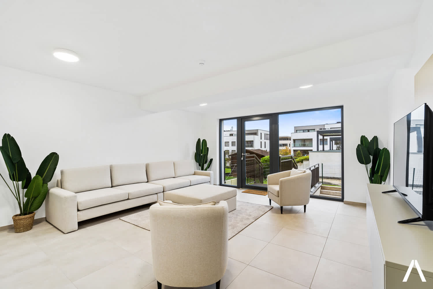 Spacious Lounge with a View – A serene shared living area with a large window overlooking the vibrant surroundings.