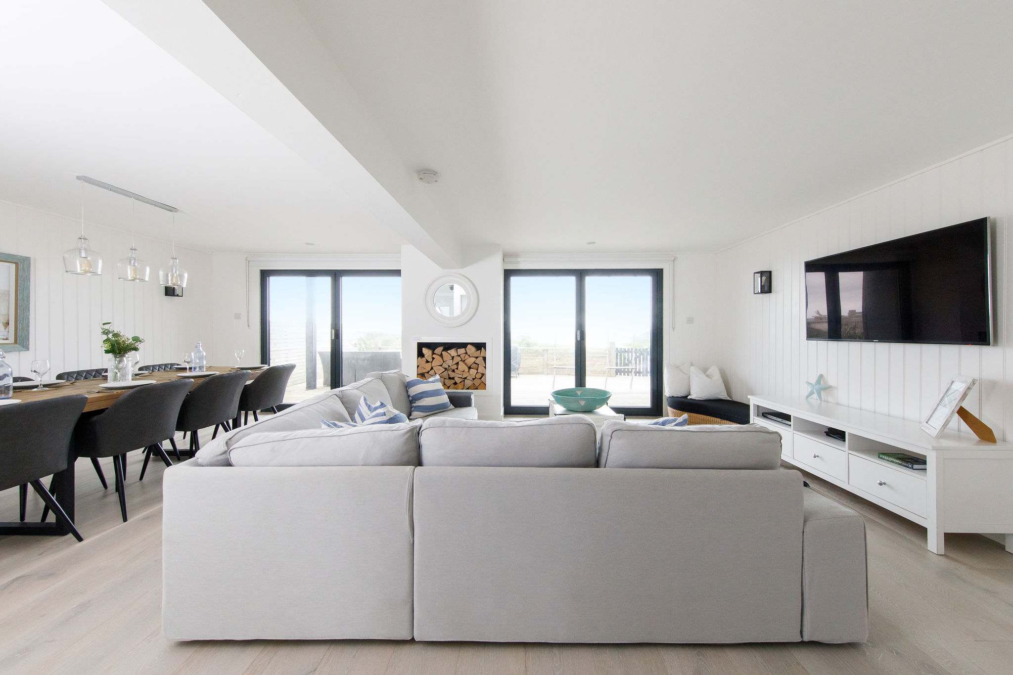 The downstairs lounge/diner with bi-fold doors out to the rear decking and beach.