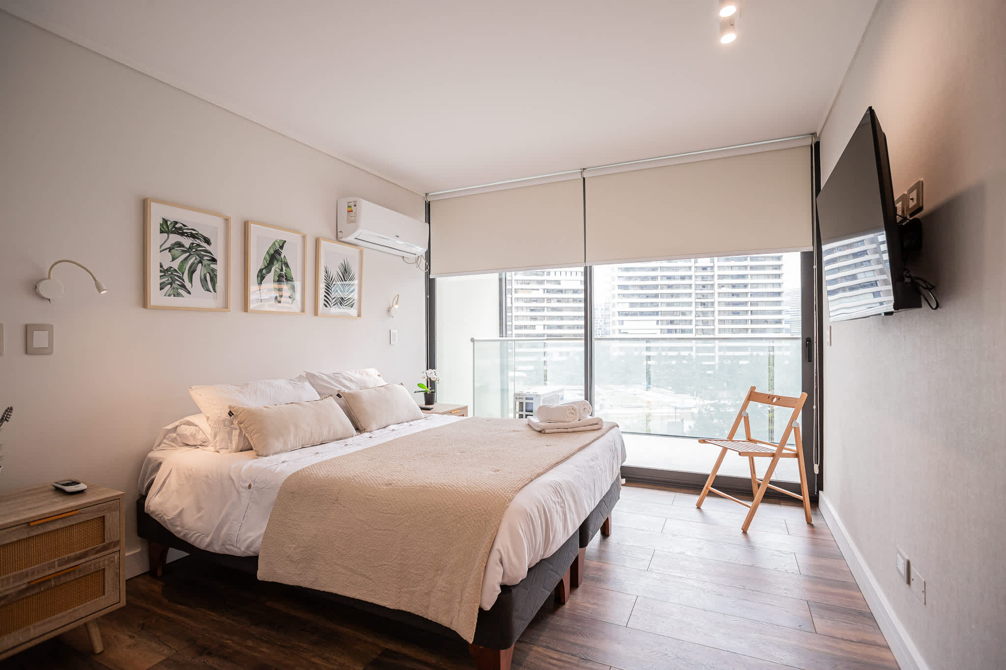 Relax in this chic bedroom with city views, cozy bedding, and modern amenities for a perfect stay in the heart of Santiago.