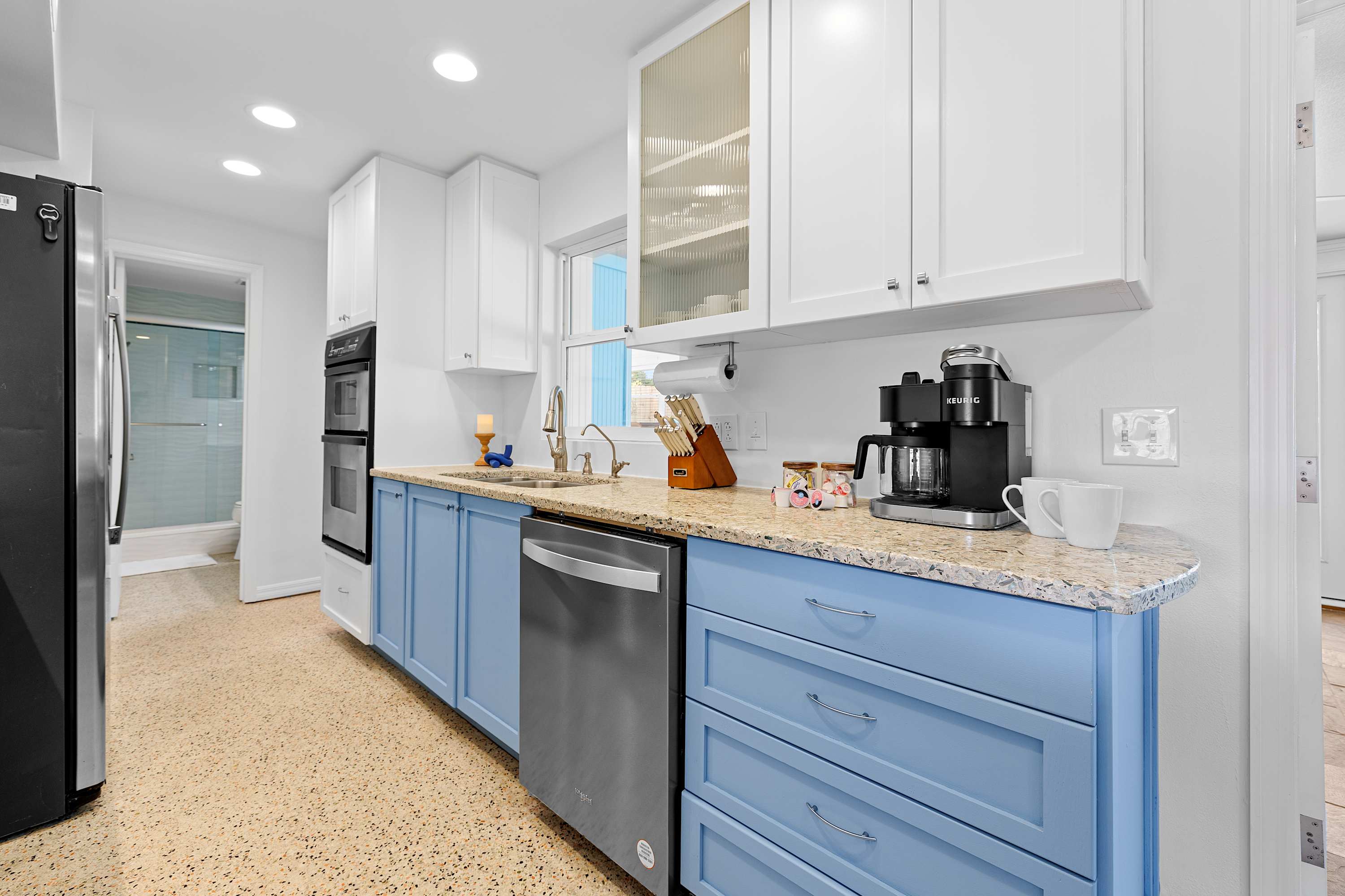 Clean, modern kitchen w/ streamlined storage and clear counters.