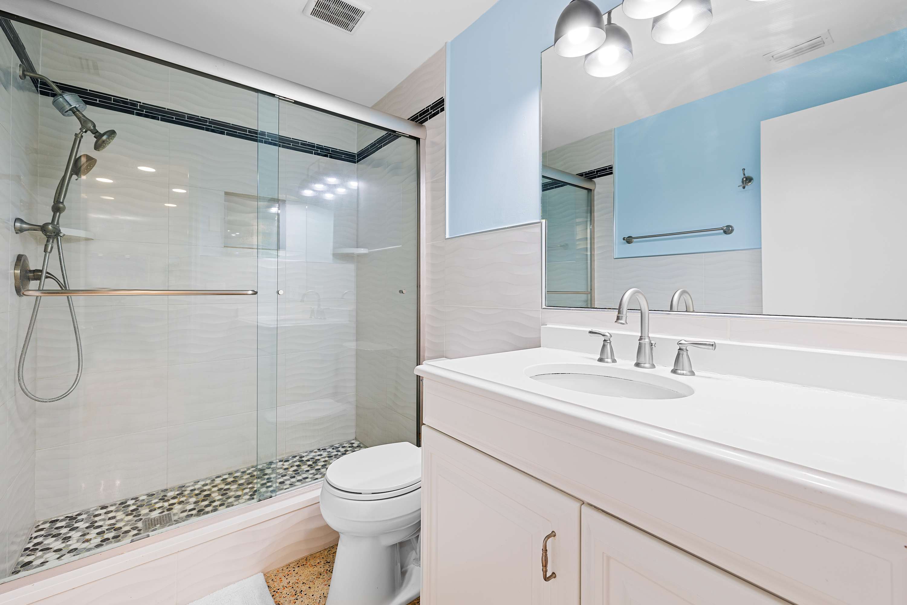 Clean bathroom w/ tub & shower combo and simple, modern finishes.