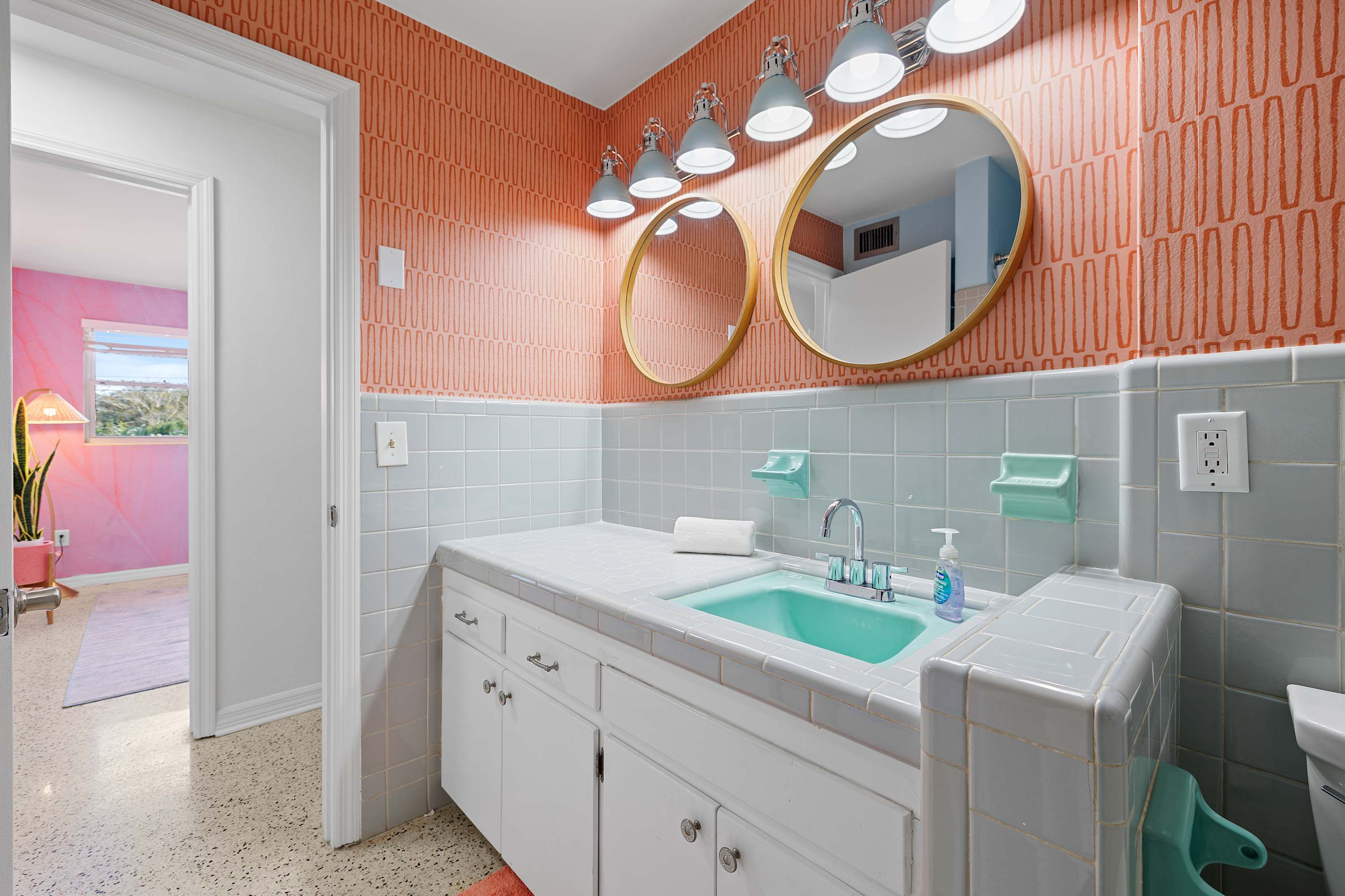 Stylish bathroom w/ double mirror setup and colorful accent details.