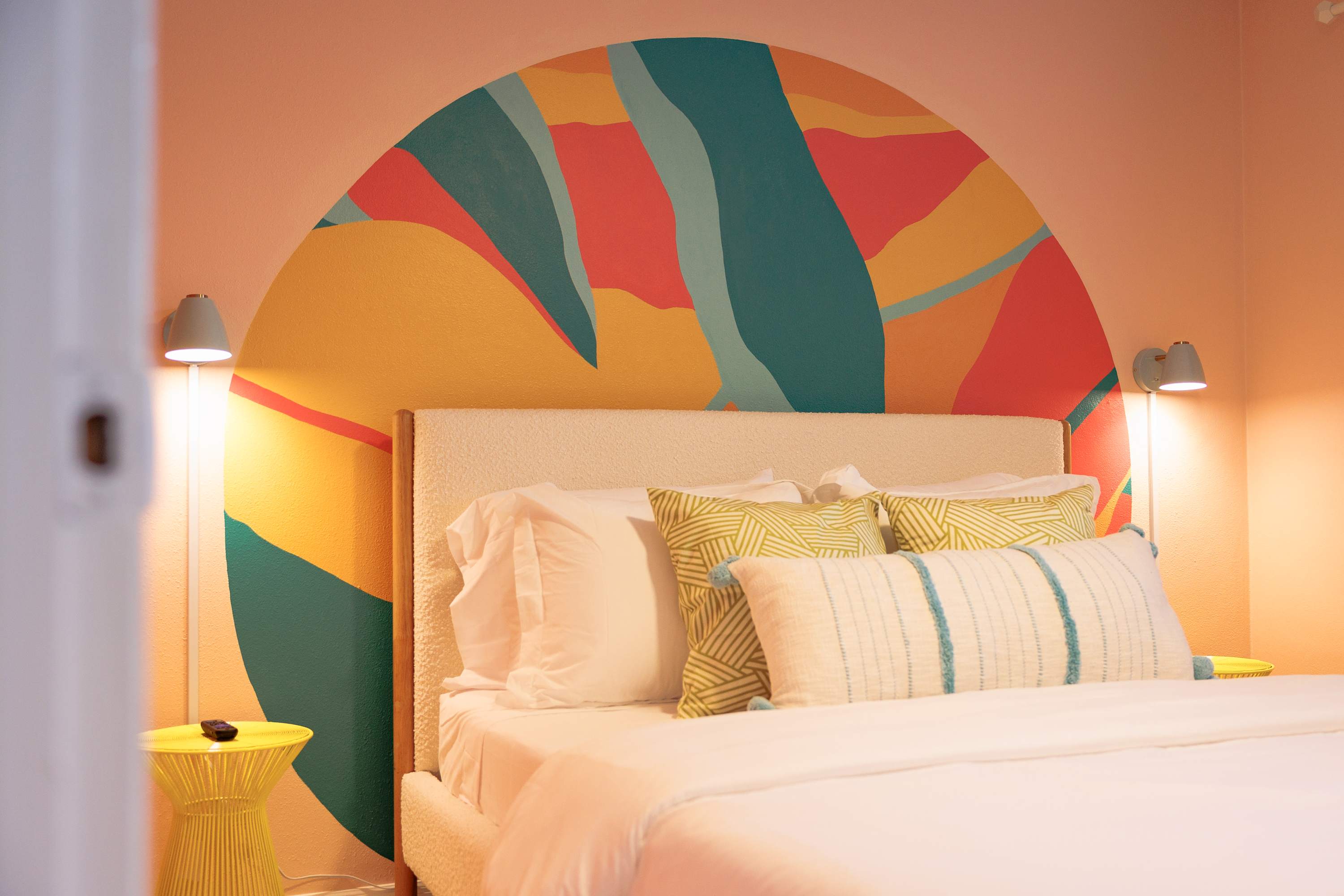 Colorful bedroom w/ bold mural accents and a fun, creative mood.