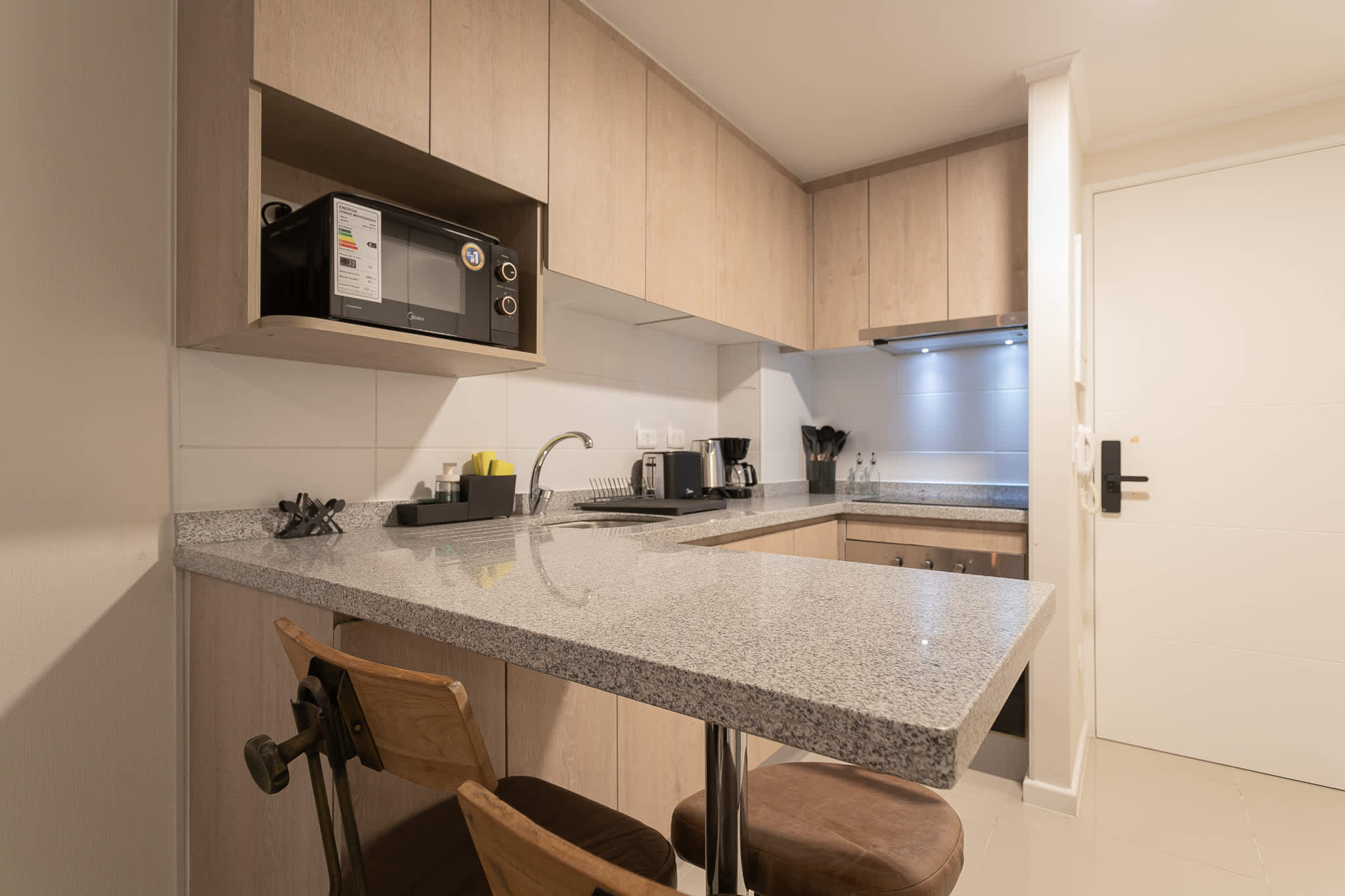 Sleek kitchen with granite countertops and modern appliances, perfect for cozy meals.
