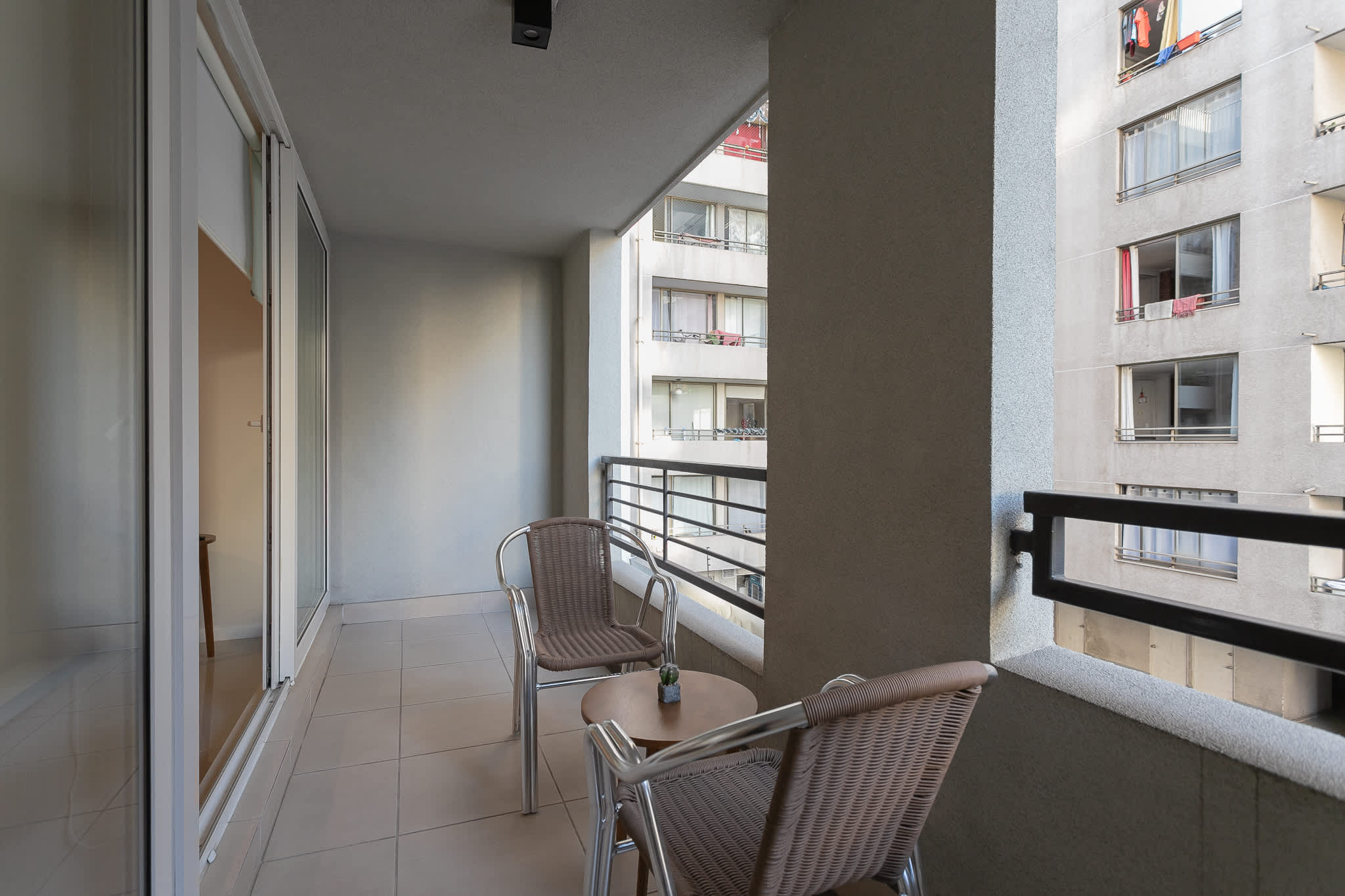 Unwind on the cozy balcony with a drink, surrounded by city views and fresh air.