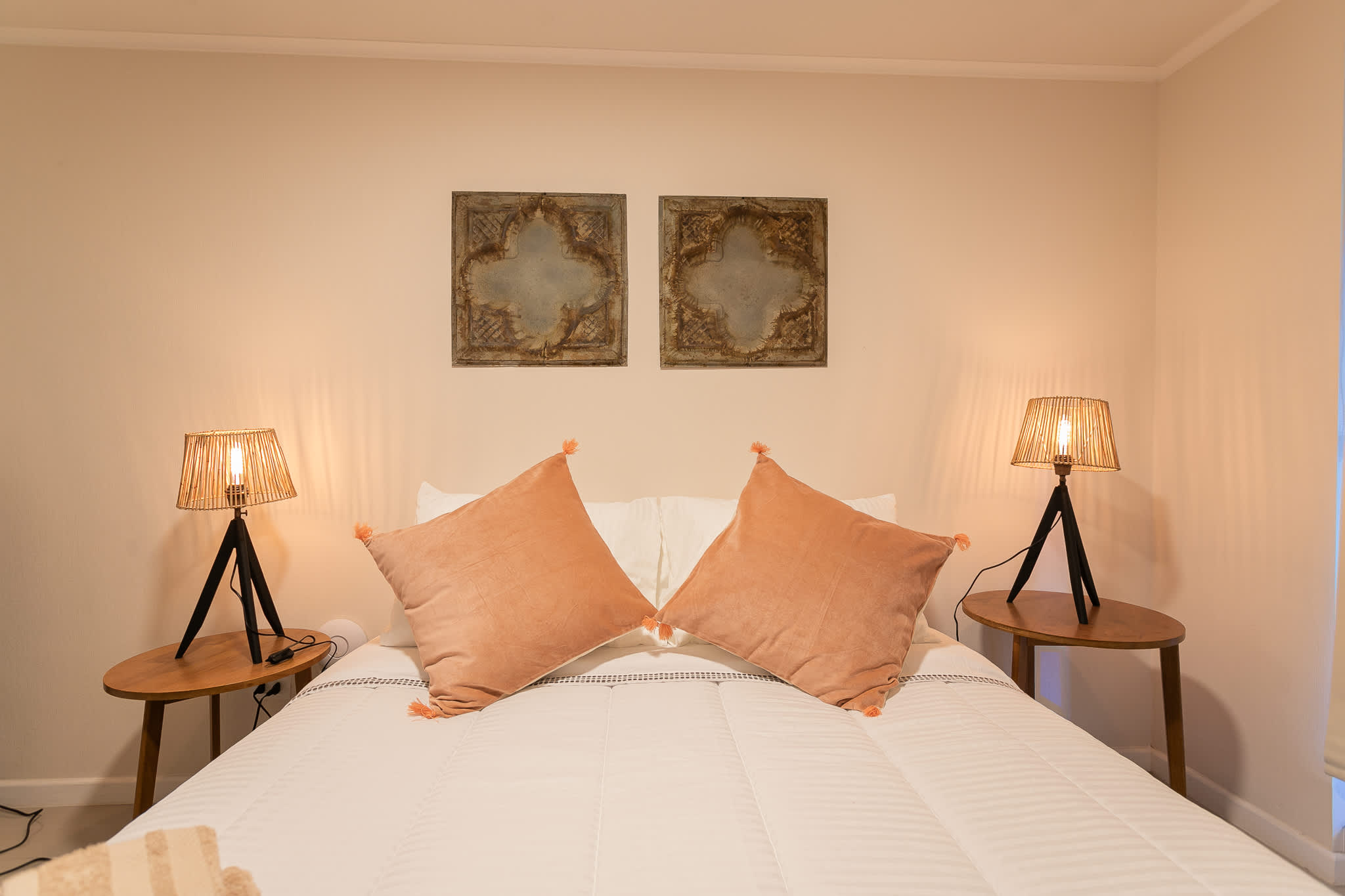 Cozy bedroom with modern lamps and elegant decor, perfect for a restful night's sleep.