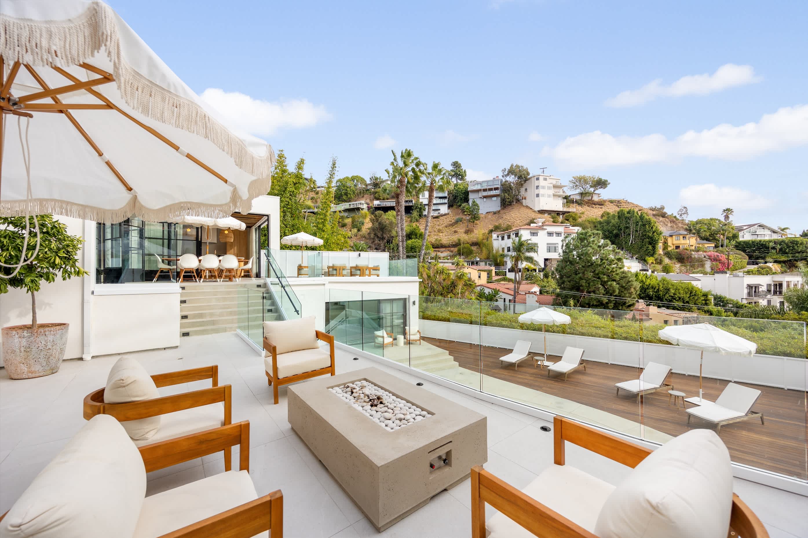 Relax by the fire pit, set in a sleek concrete base, with panoramic hillside views.